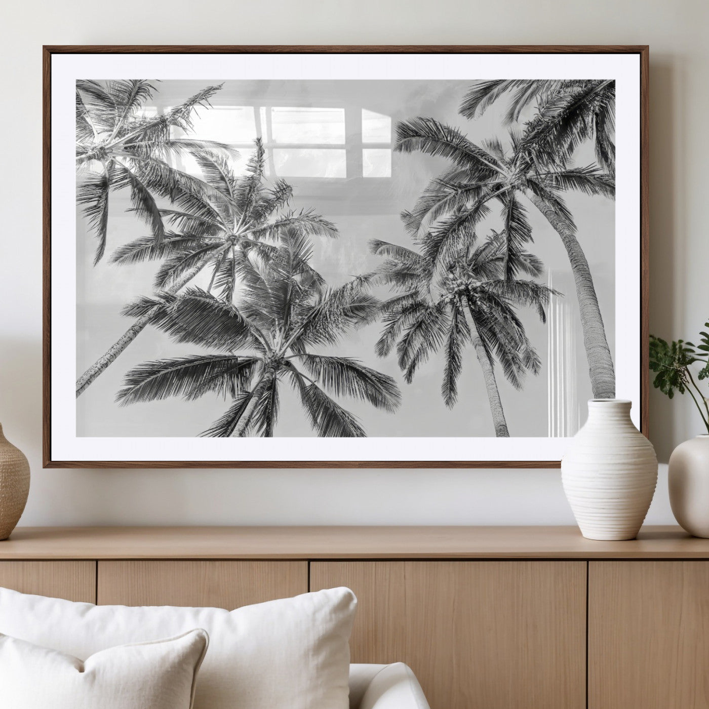 Black and white tropical palm trees viewed from below, swaying gently against a bright sky, creating a serene and elegant coastal atmosphere.