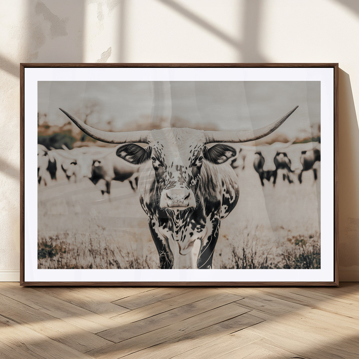 Canvas of a speckled Texas longhorn standing boldly in a field with a herd behind, perfect for rustic western or farmhouse wall decor.