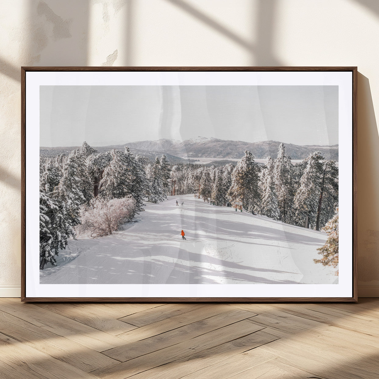 Bright ski trail lined with snow-covered pines and a skier in orange, perfect for alpine adventure or winter sports-inspired decor.