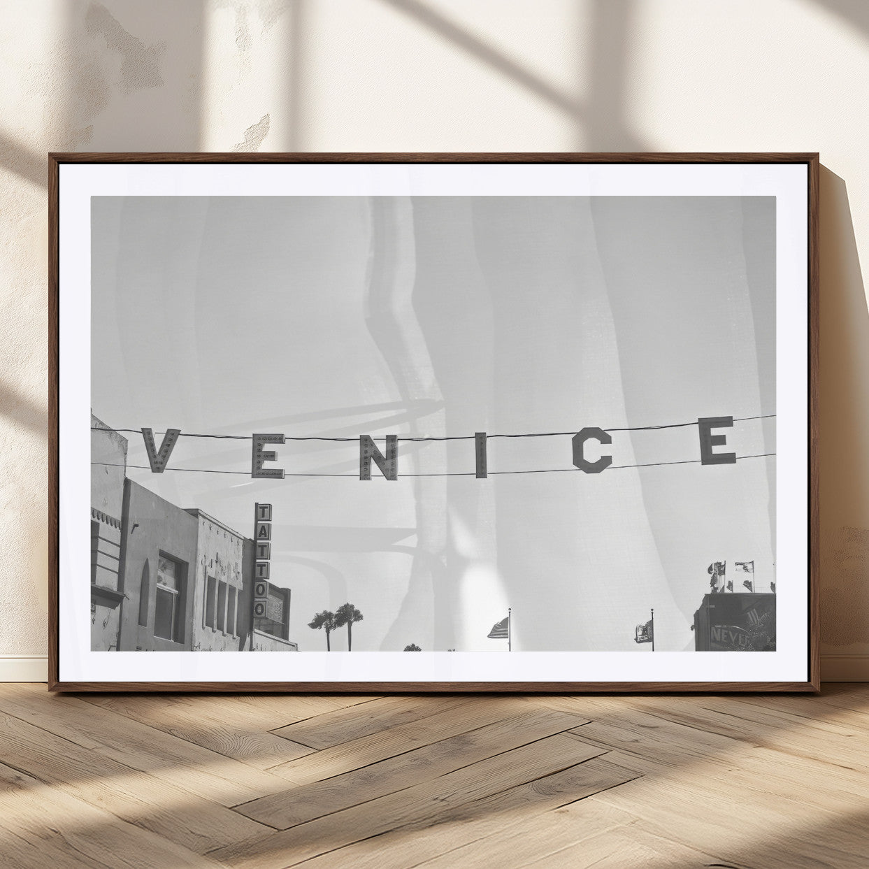 Black and white photo of Venice Beach sign and palm-lined street, perfect for urban coastal or minimalist LA-inspired wall decoration.