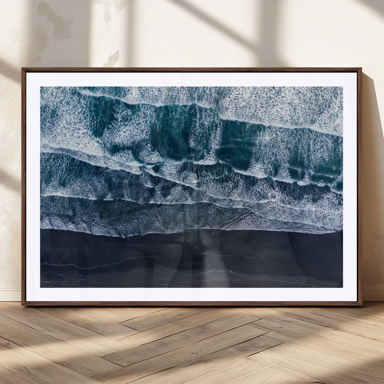 Canvas of aerial ocean waves crashing onto a black sand beach in moody tones, ideal for modern coastal or minimalist home decor.