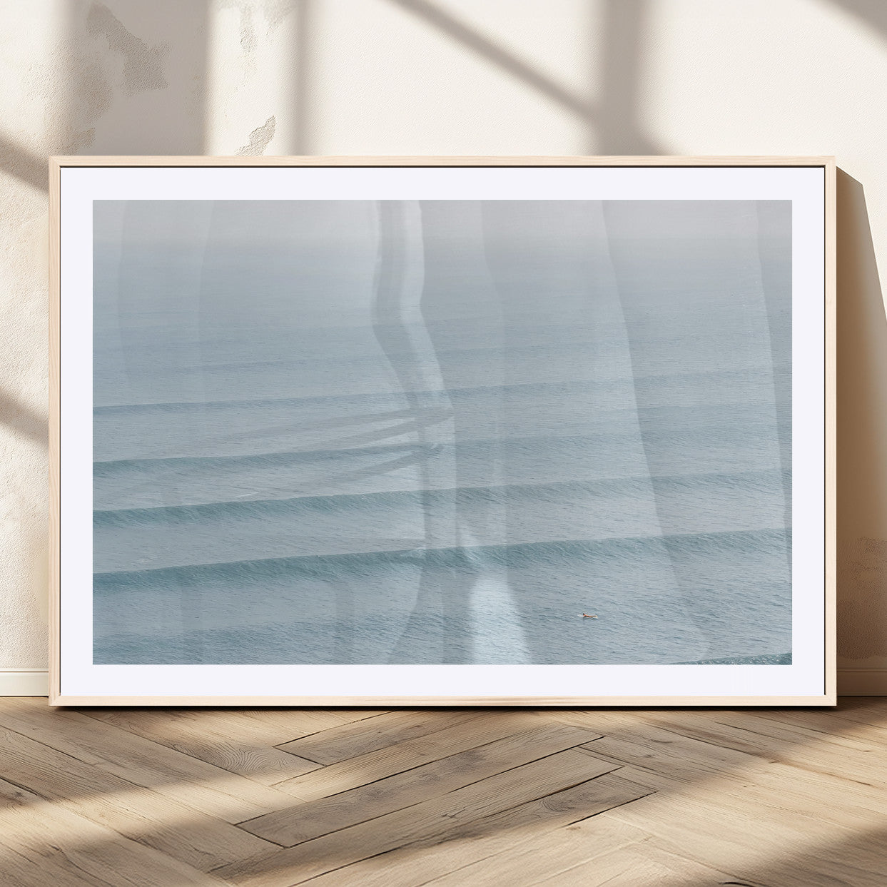 Framed canvas of repeating ocean waves with a distant solo surfer, ideal for minimalist ocean or calm coastal wall decor.