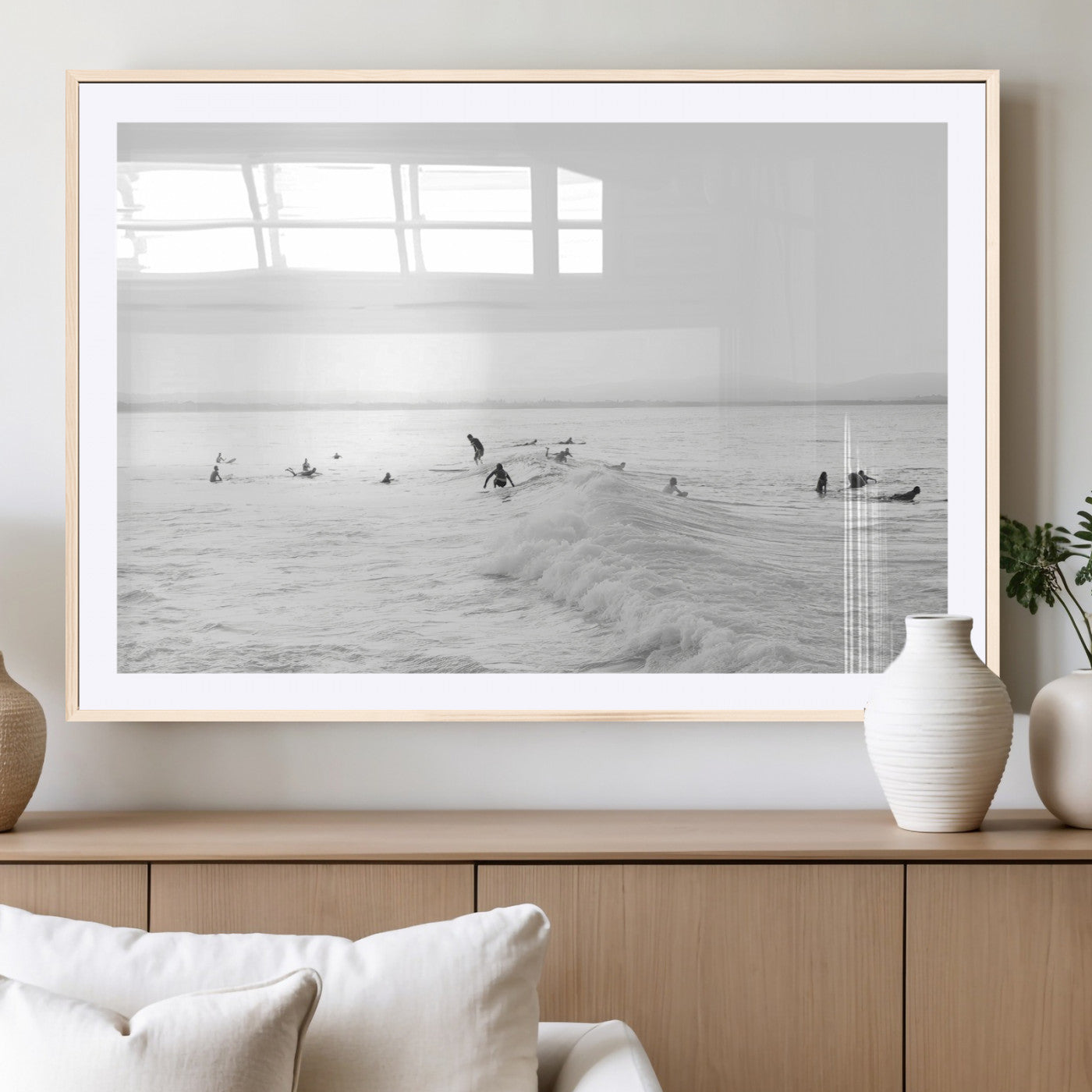 Monochrome photo of surfers riding and waiting on ocean waves, ideal for surf-themed or coastal energy wall decor.