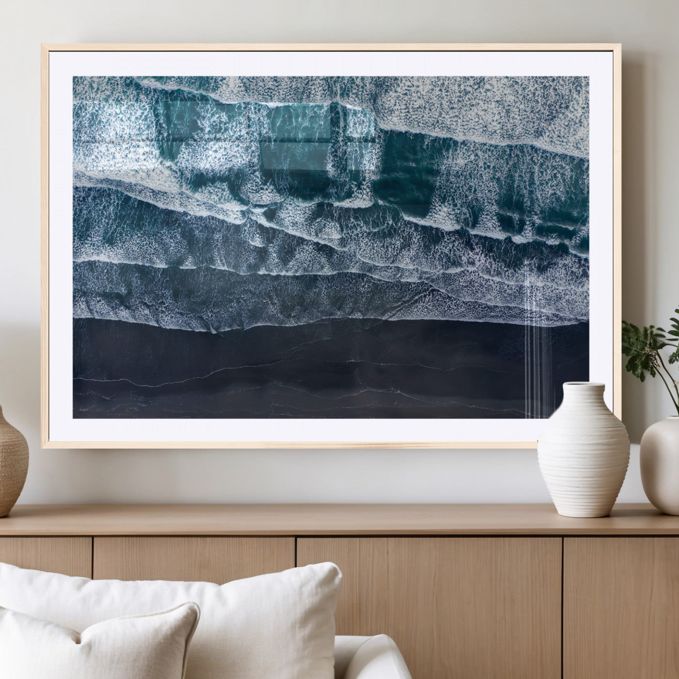 Canvas of aerial ocean waves crashing onto a black sand beach in moody tones, ideal for modern coastal or minimalist home decor.