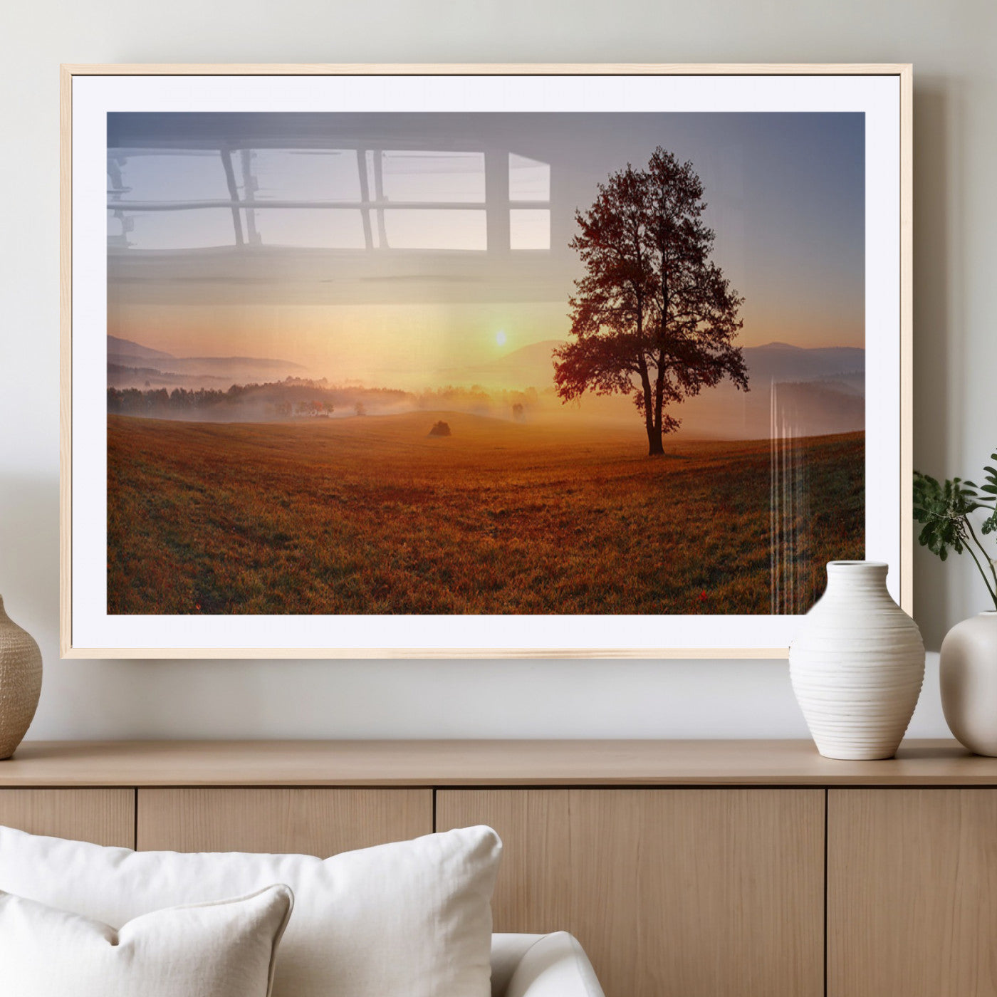 A tranquil landscape at sunrise with a mist-covered field and a lone tree, creating a peaceful and natural atmosphere.