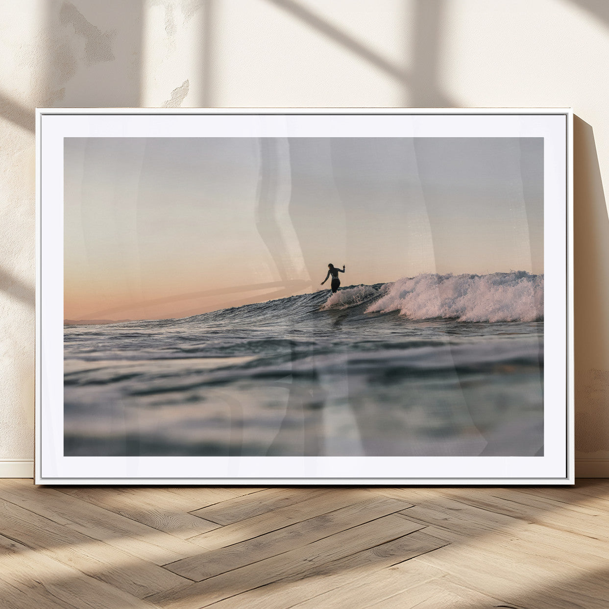 Framed canvas of a female surfer balancing on a wave at sunset, perfect for serene surf or ocean-inspired coastal decor.