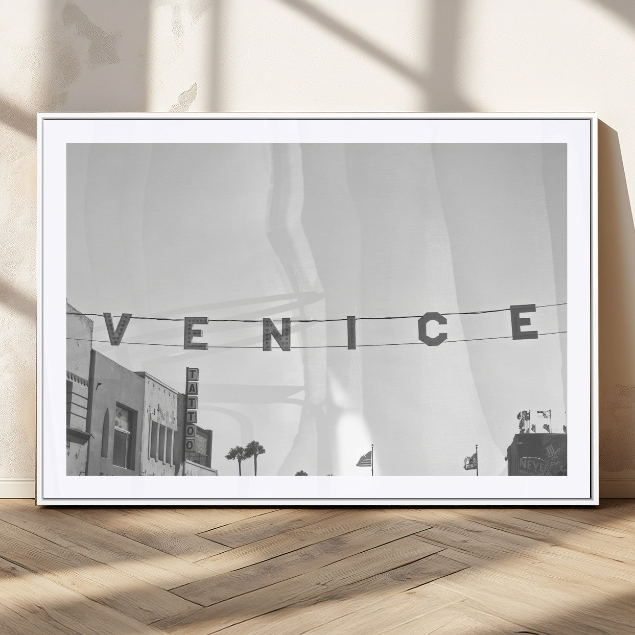 Black and white photo of Venice Beach sign and palm-lined street, perfect for urban coastal or minimalist LA-inspired wall decoration.