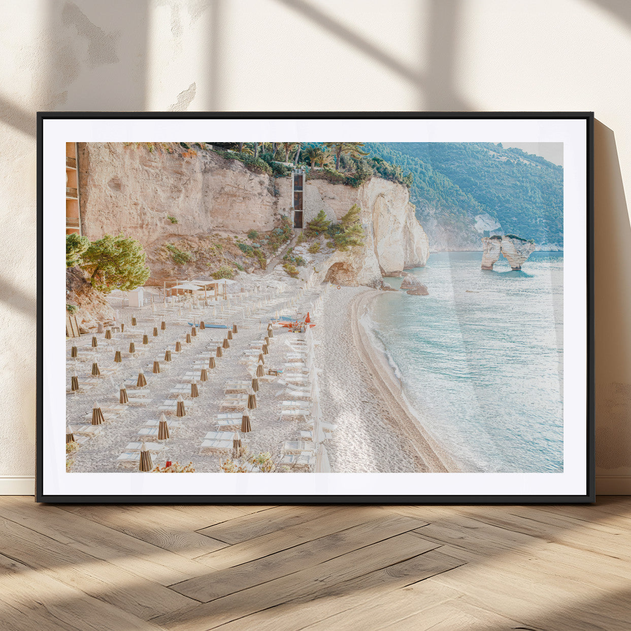 Wall art of a calm Mediterranean beach with rows of sun loungers and umbrellas in soft pastel tones, perfect for light coastal or vacation-themed decor.
