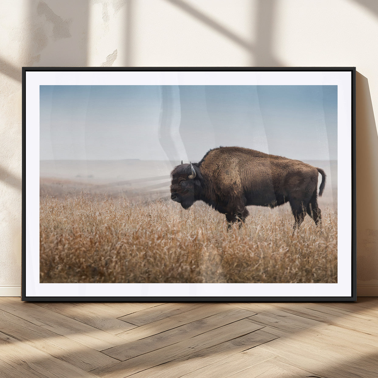 A majestic bison standing in an open prairie field, its strong form blending into the golden grass under a vast blue sky, evoking the wild spirit of the American plains.