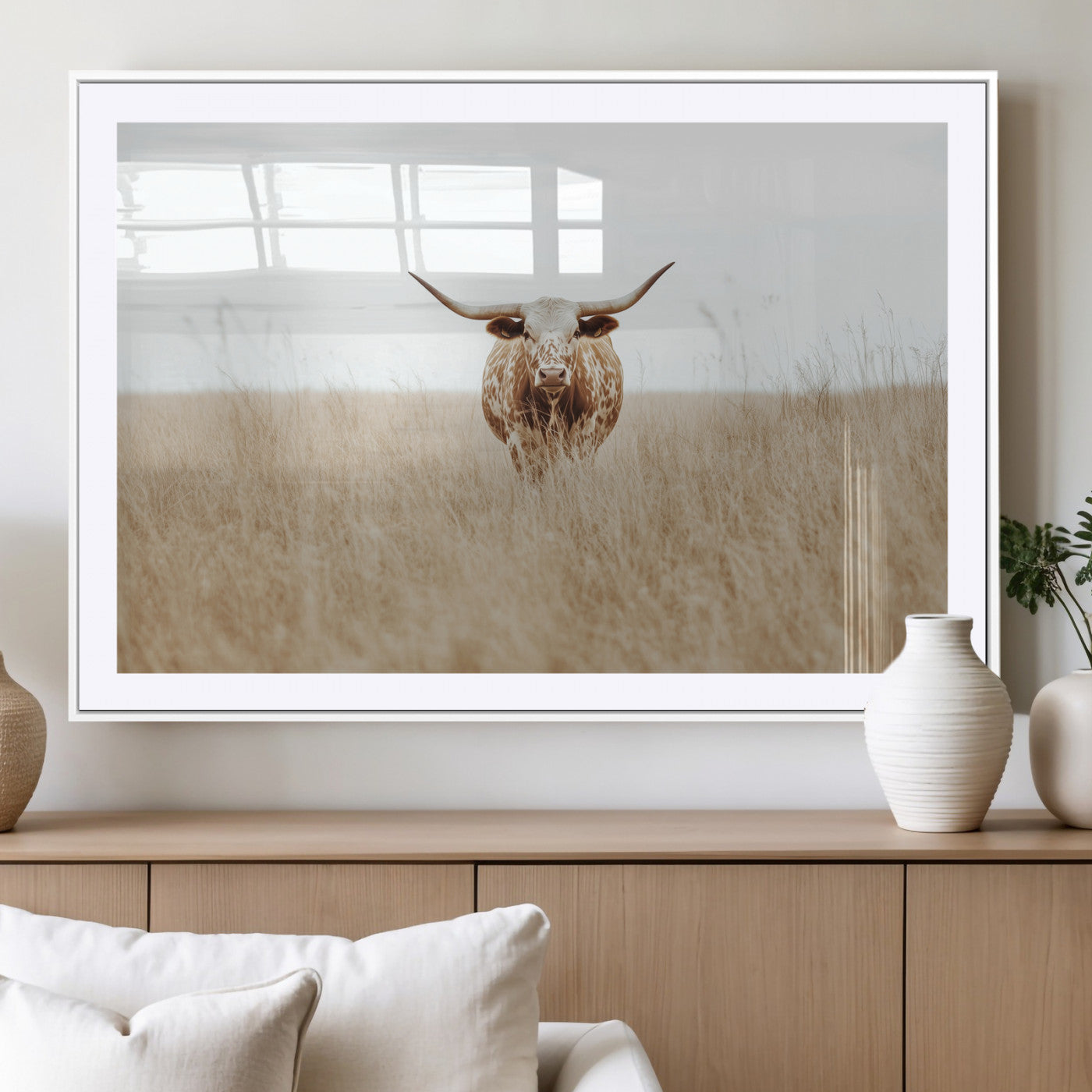 Texas Longhorn bull standing alone in dry grass with neutral tones, ideal for rustic western or cowboy-themed wall decor.
