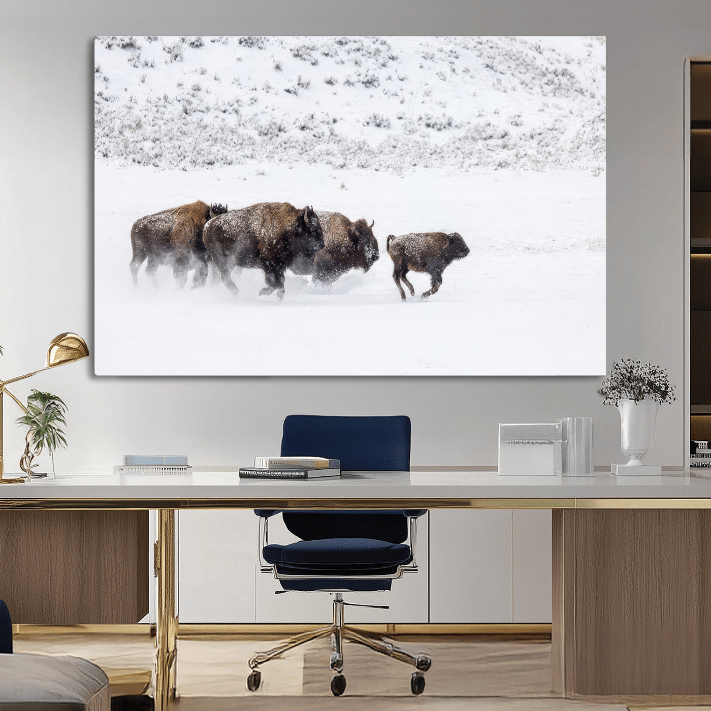 Bison herd running through a snowy open field with mountain backdrop, perfect for rustic or western-themed wall decoration.