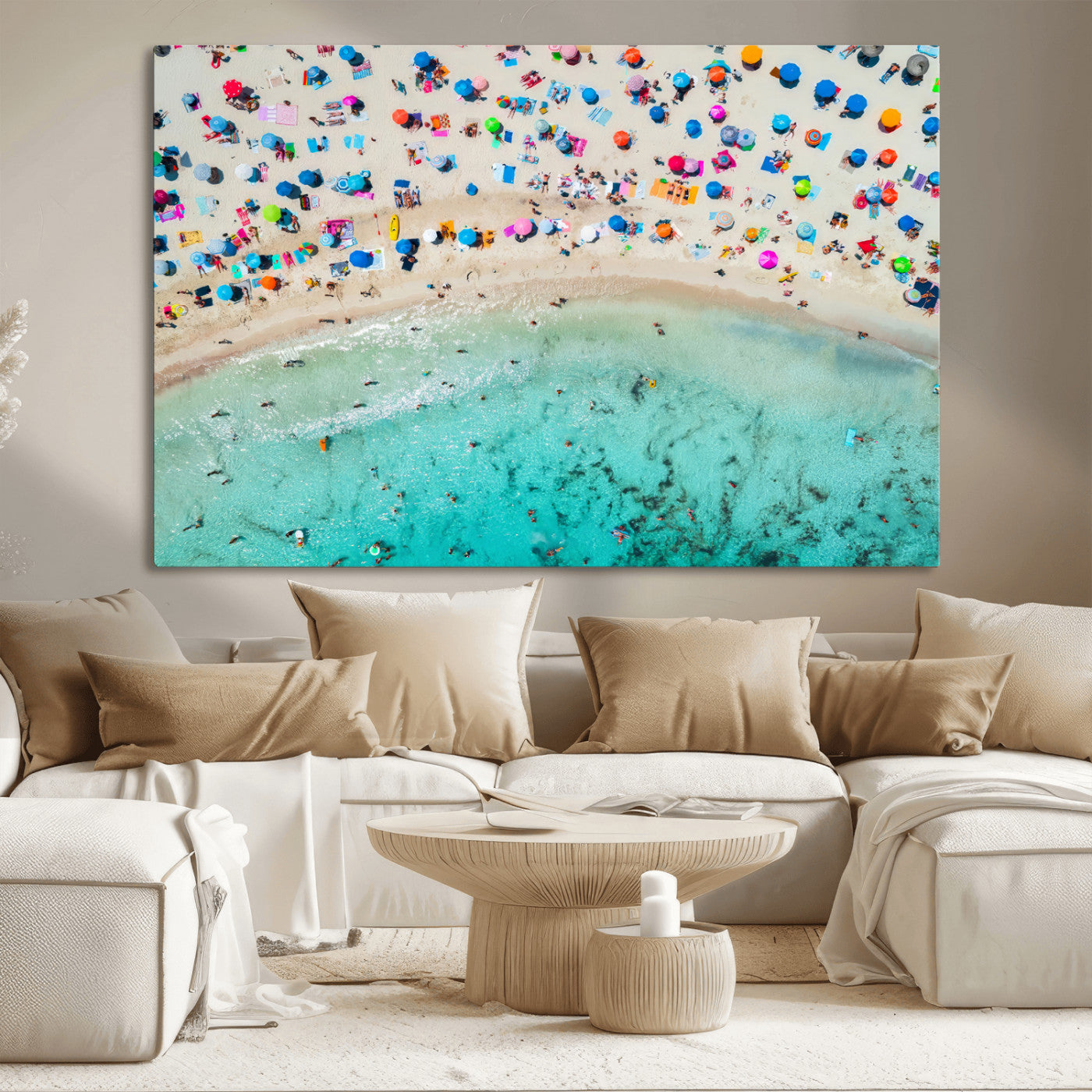 Aerial view of a vibrant beach filled with colorful umbrellas and people enjoying the turquoise ocean, capturing a lively summer vacation scene.