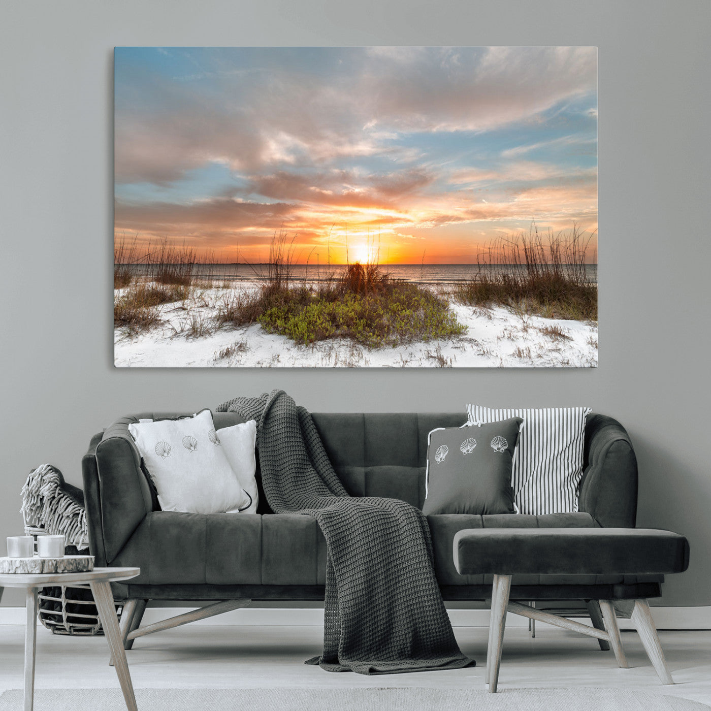 A tranquil beach scene featuring golden sunset hues over the water, with grasses in the foreground and a peaceful, serene atmosphere.