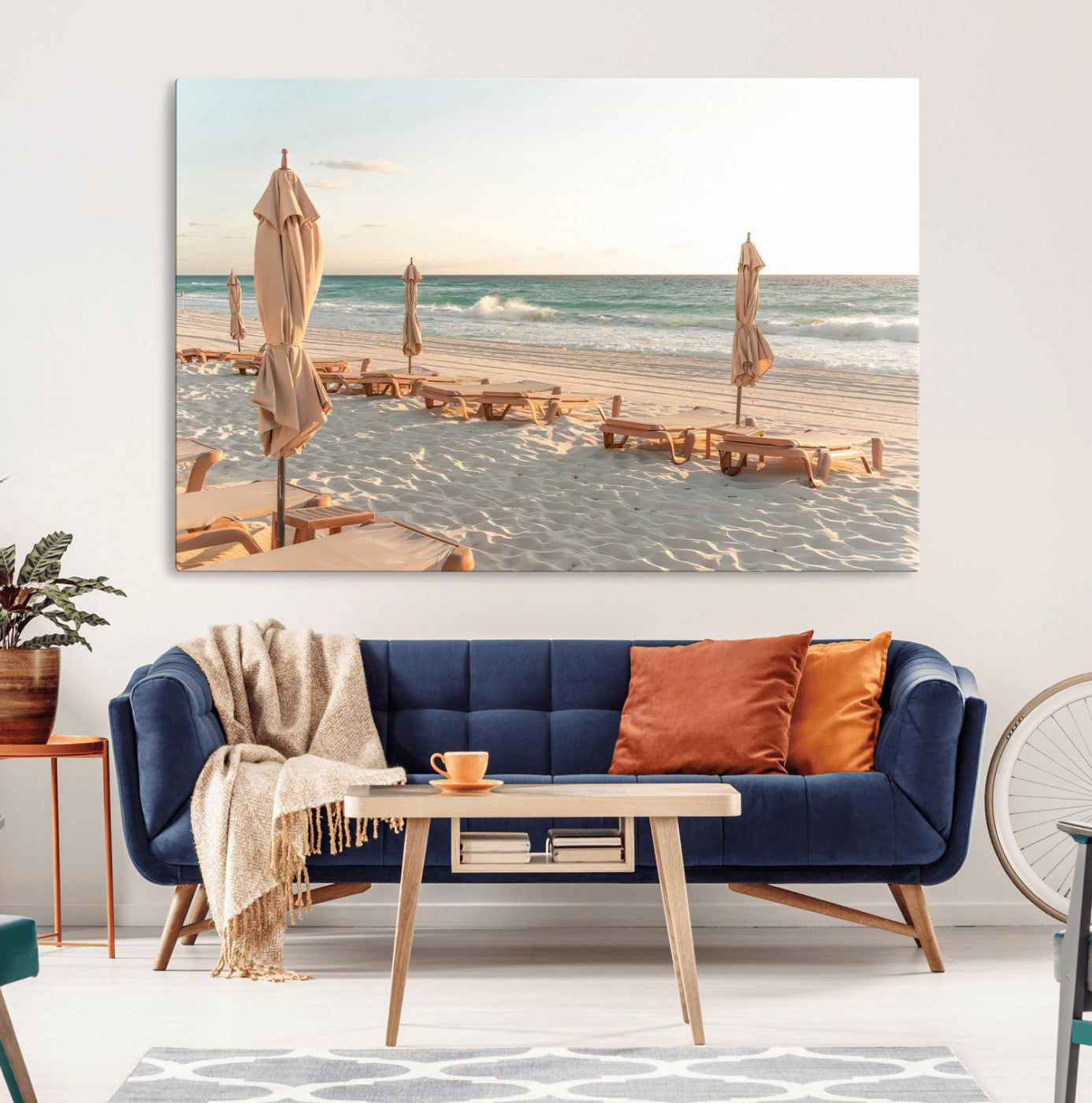 Minimalist photo of empty beach loungers and umbrellas on soft sand, ideal for calm seaside or pastel coastal-style home decor.