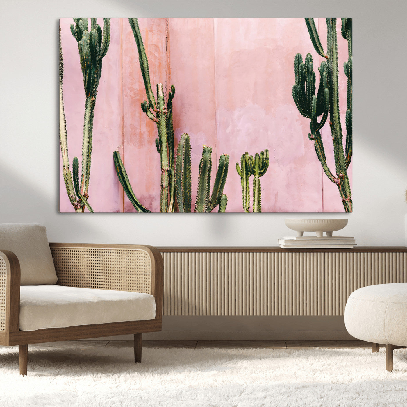 Framed canvas of tall green cacti against a soft pink wall, ideal for modern desert or colorful southwest-inspired home decor.