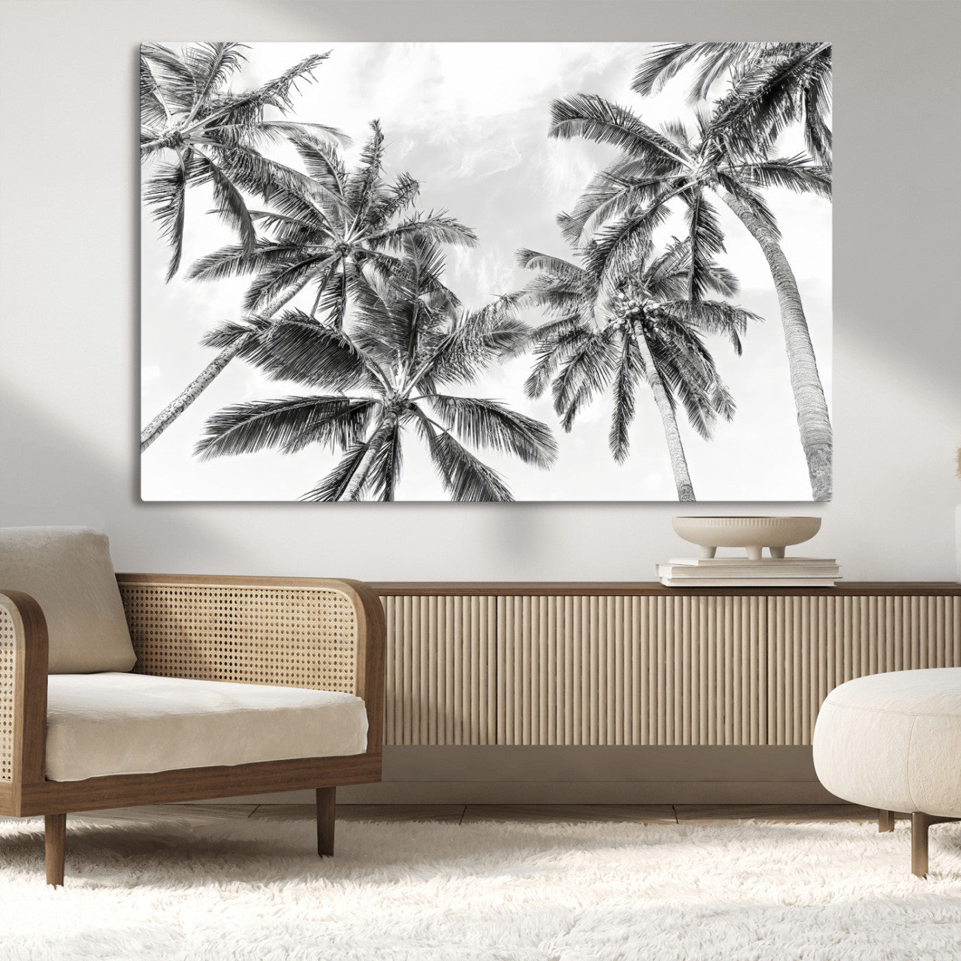 Black and white tropical palm trees viewed from below, swaying gently against a bright sky, creating a serene and elegant coastal atmosphere.