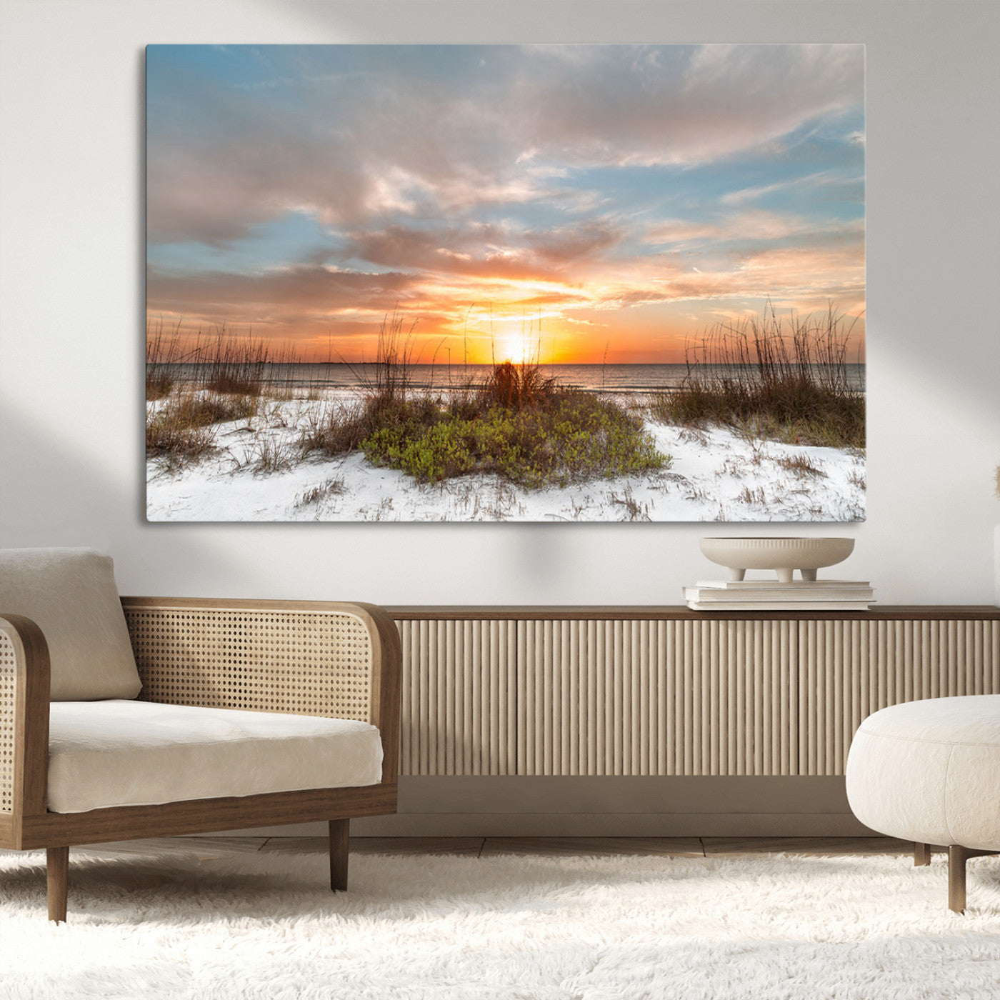 A tranquil beach scene featuring golden sunset hues over the water, with grasses in the foreground and a peaceful, serene atmosphere.