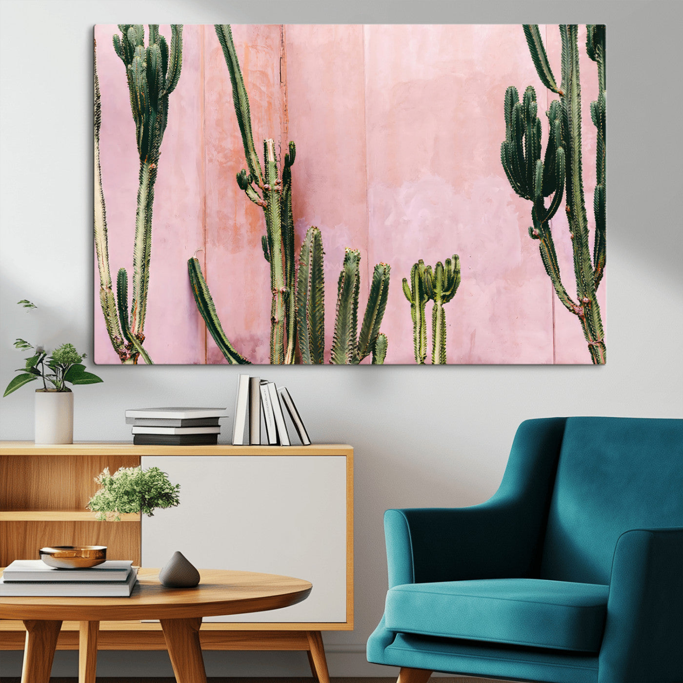 Framed canvas of tall green cacti against a soft pink wall, ideal for modern desert or colorful southwest-inspired home decor.