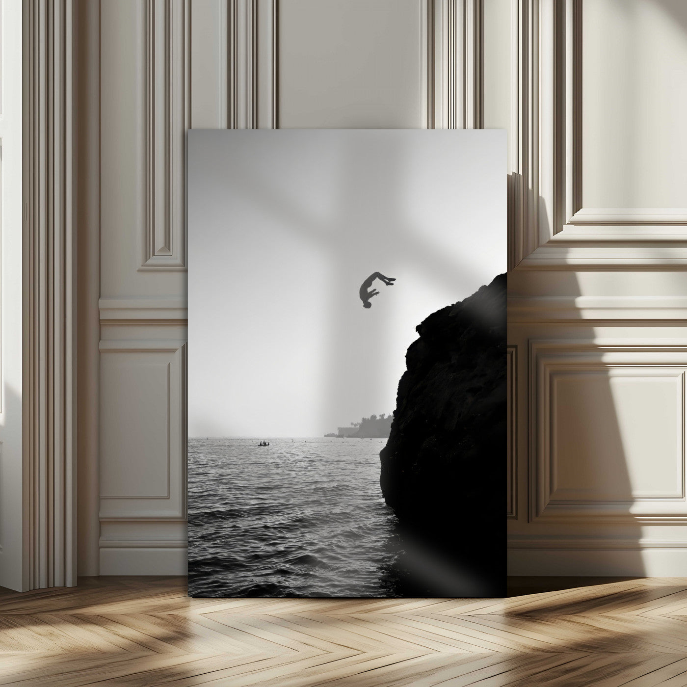 Silhouette of a person mid-air during a cliff jump over the ocean, captured in black and white for minimalist adventure decor.