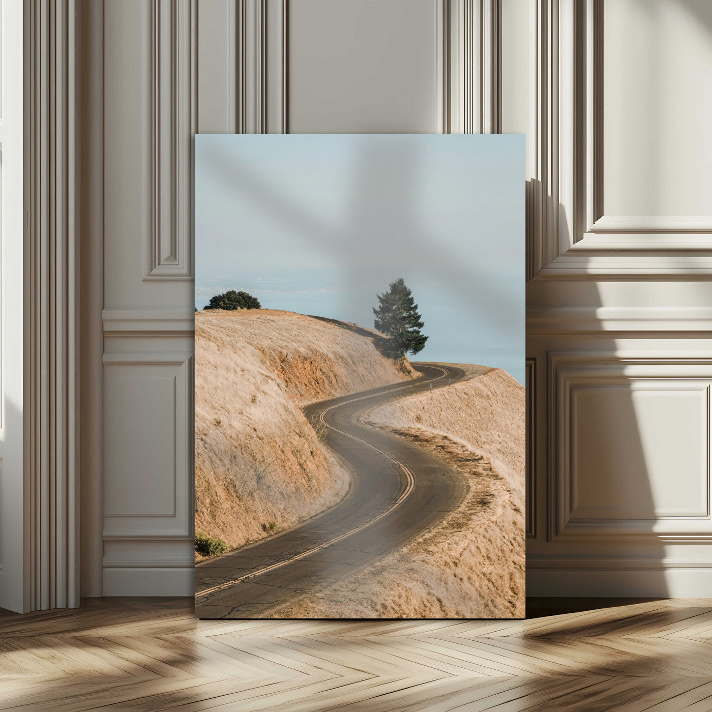 Earth-toned photograph of a winding road through golden hills, ideal for neutral or rustic-themed decor with a calming travel vibe.