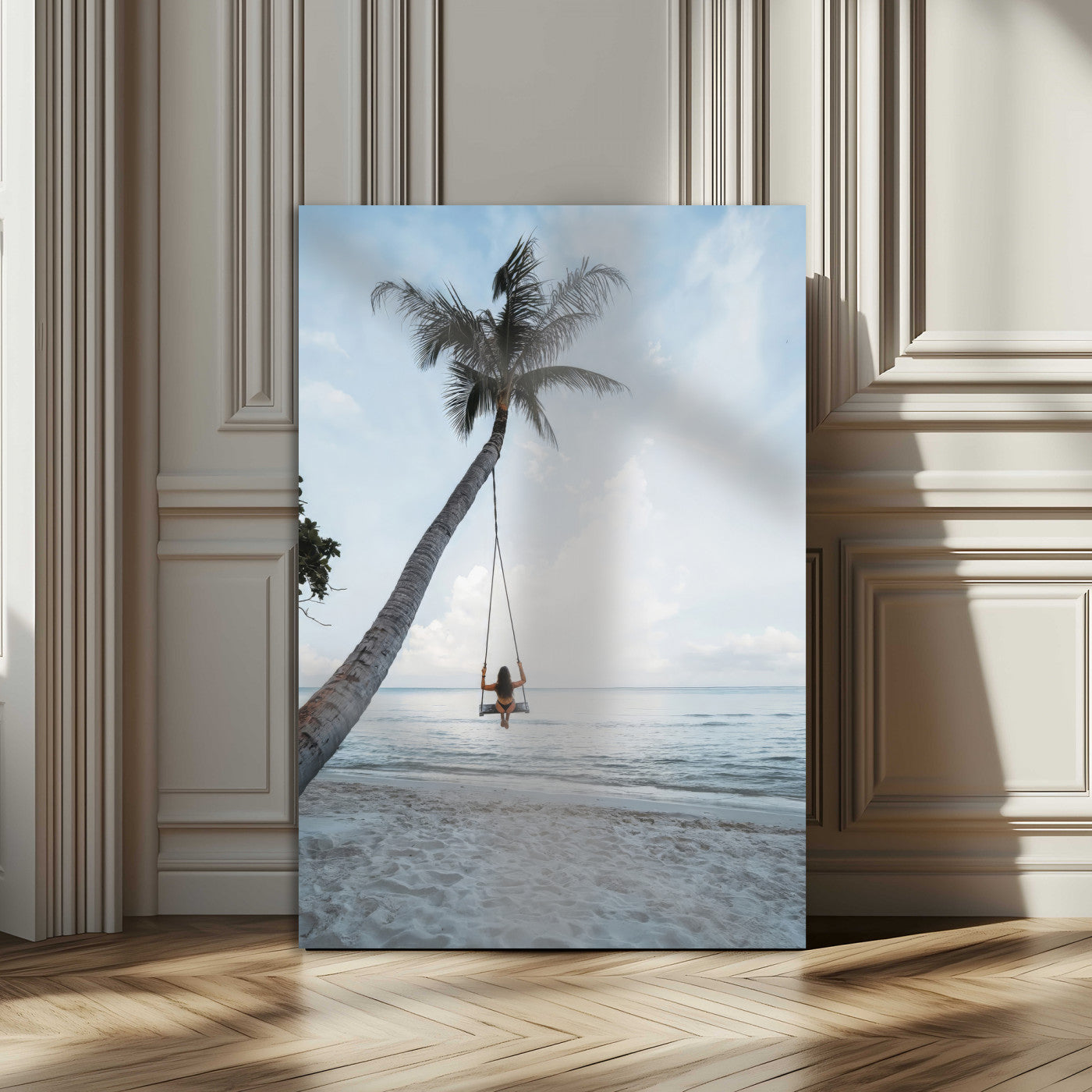 Wall art of a girl on a swing hanging from a palm tree over calm ocean waters, perfect for tropical or minimalist coastal decor.