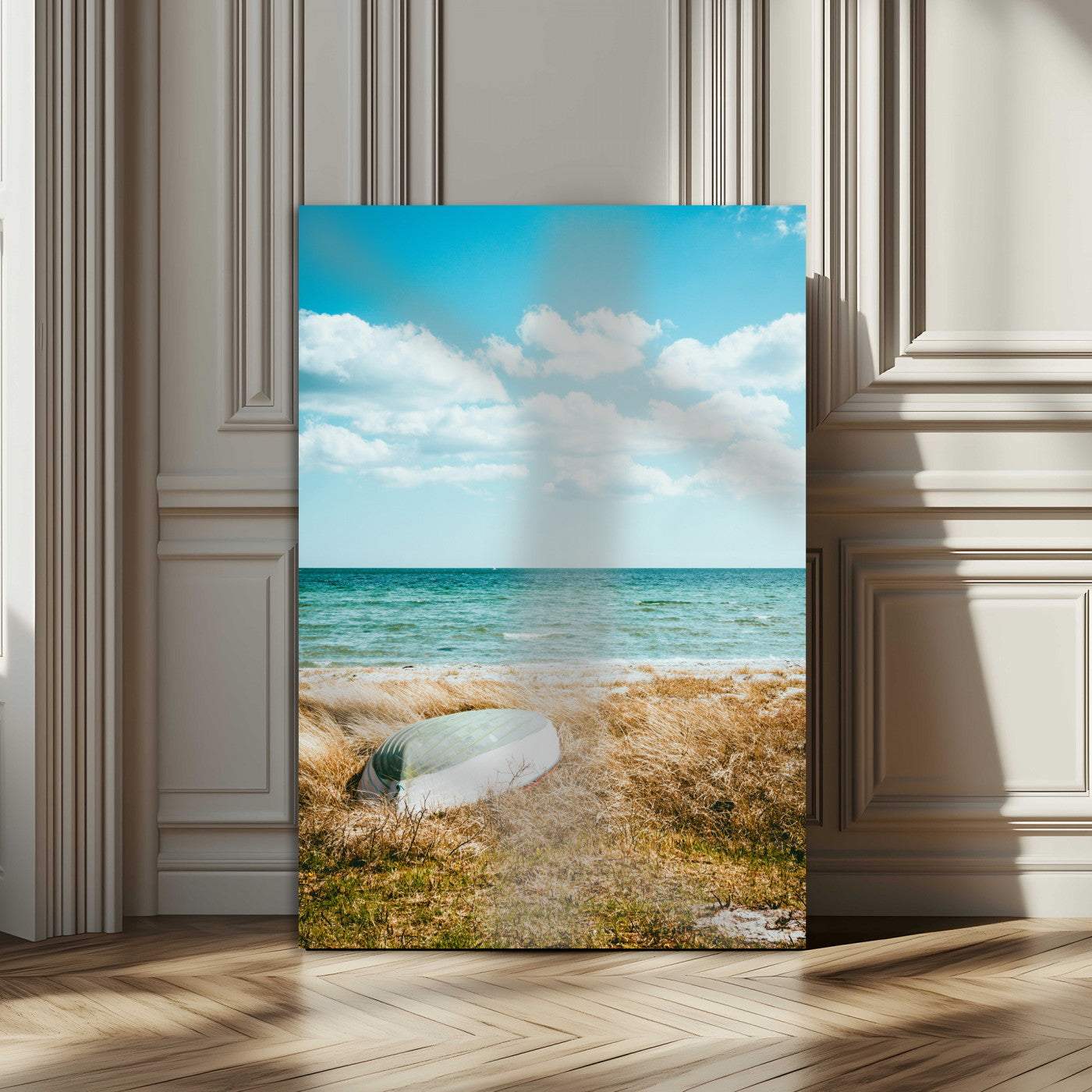 A small boat resting on a grassy shore with ocean waves and a bright blue sky, creating a peaceful coastal atmosphere.