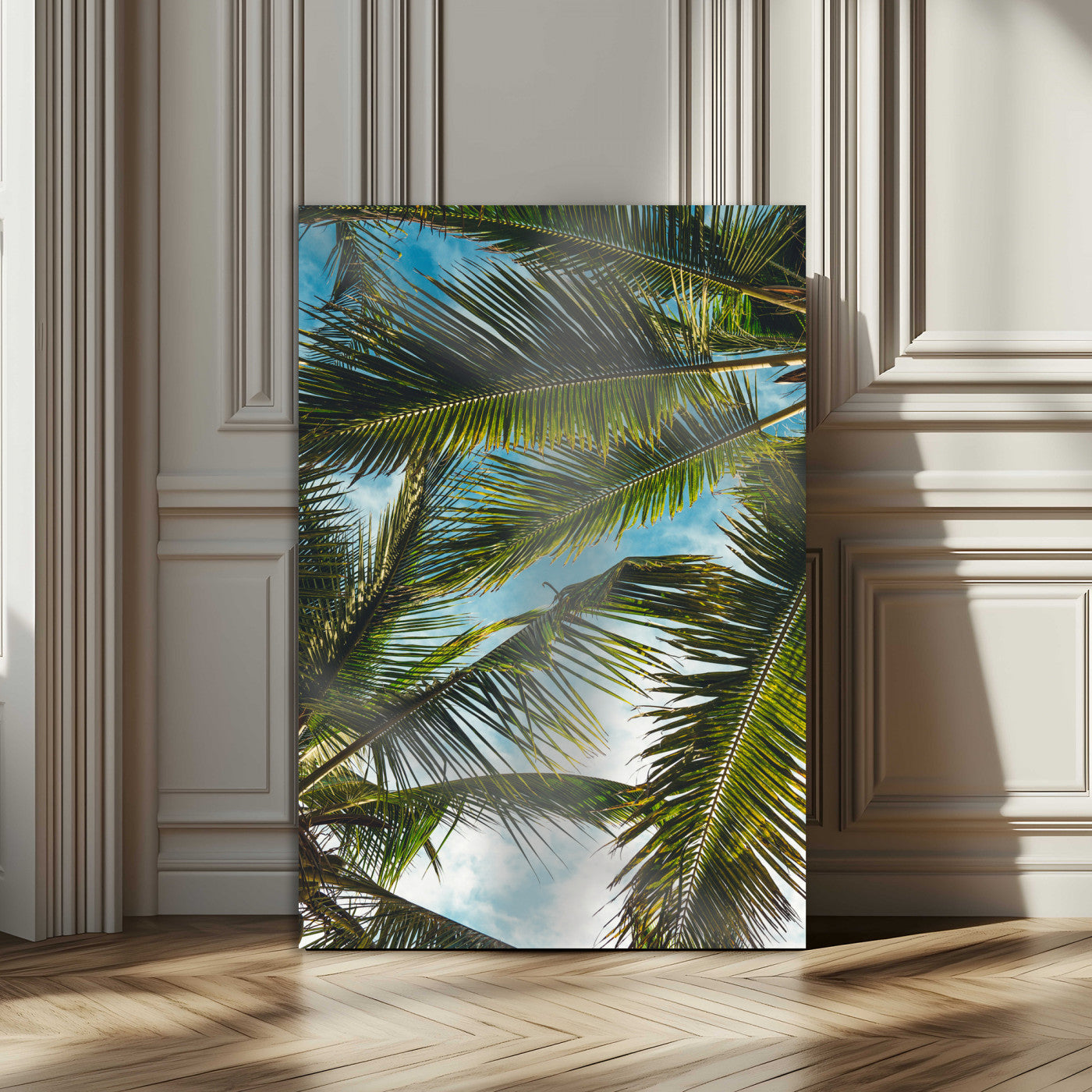 Looking up at lush green palm leaves against a bright blue sky, creating a tropical and relaxing coastal aesthetic.