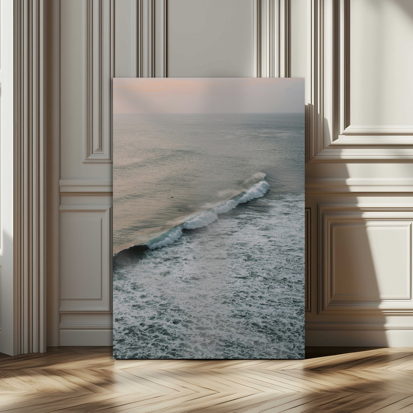 Aerial view of ocean waves rolling towards the shore under a soft sunset sky, creating a peaceful and minimalist coastal scene.