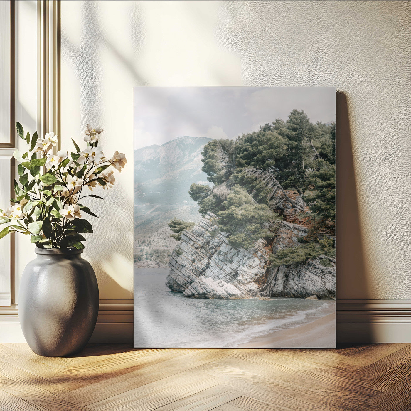 Framed photo of a rocky coastal cliff with dense greenery and calm shoreline, ideal for rustic coastal or earthy-toned home decor.