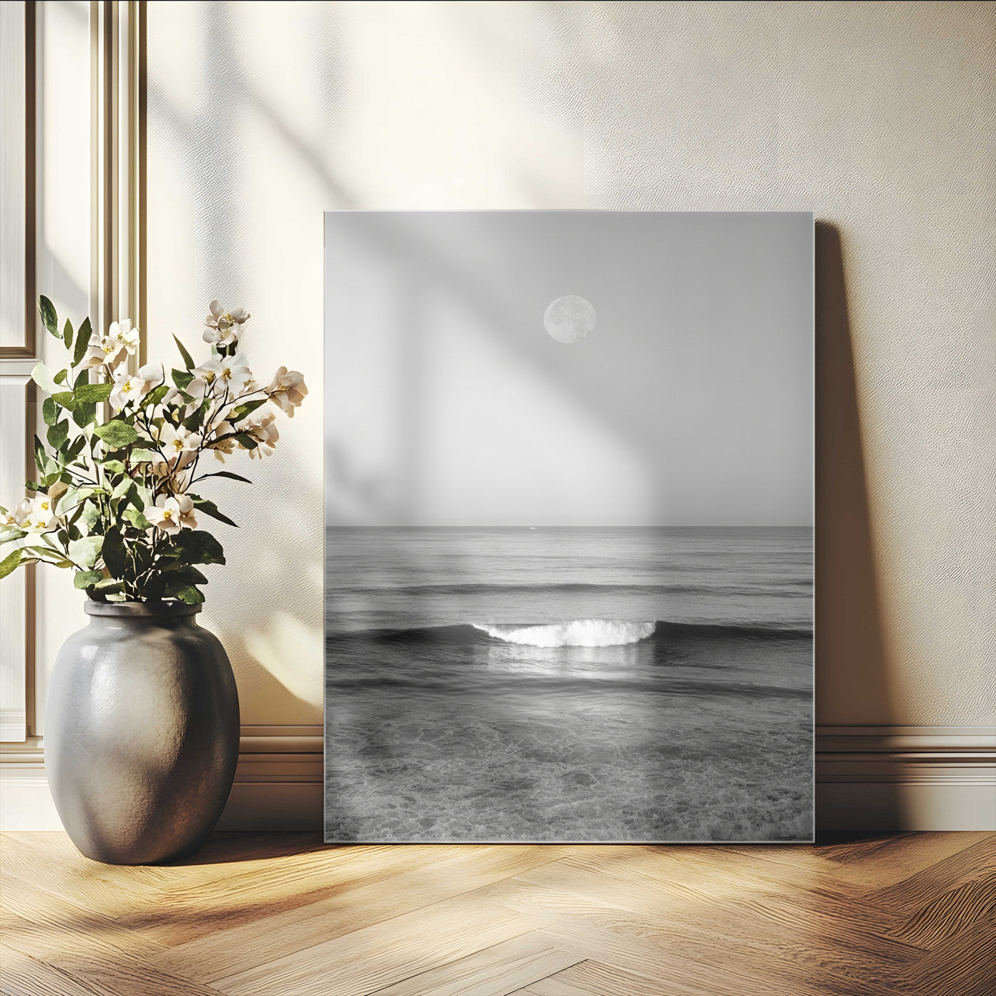 Black and white wall art of a calm ocean wave beneath a full moon, ideal for minimalist or monochrome coastal decor.