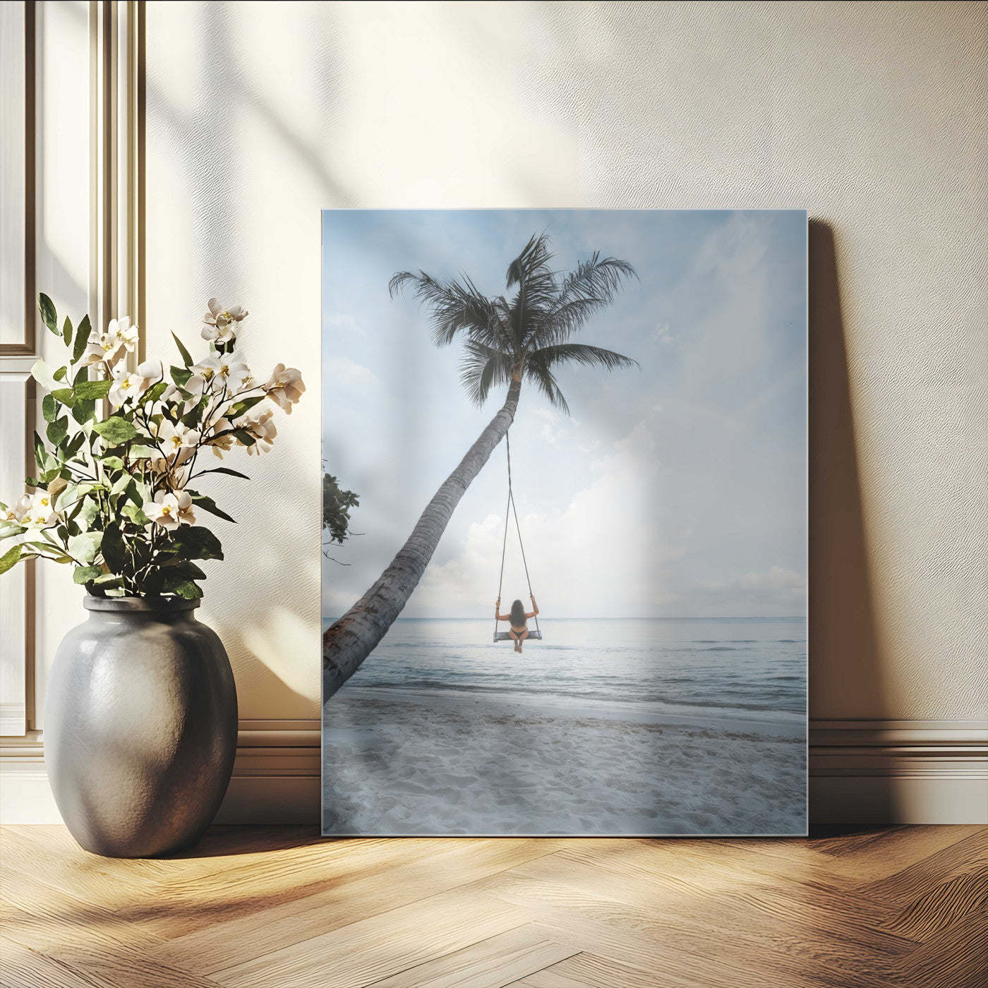 Wall art of a girl on a swing hanging from a palm tree over calm ocean waters, perfect for tropical or minimalist coastal decor.