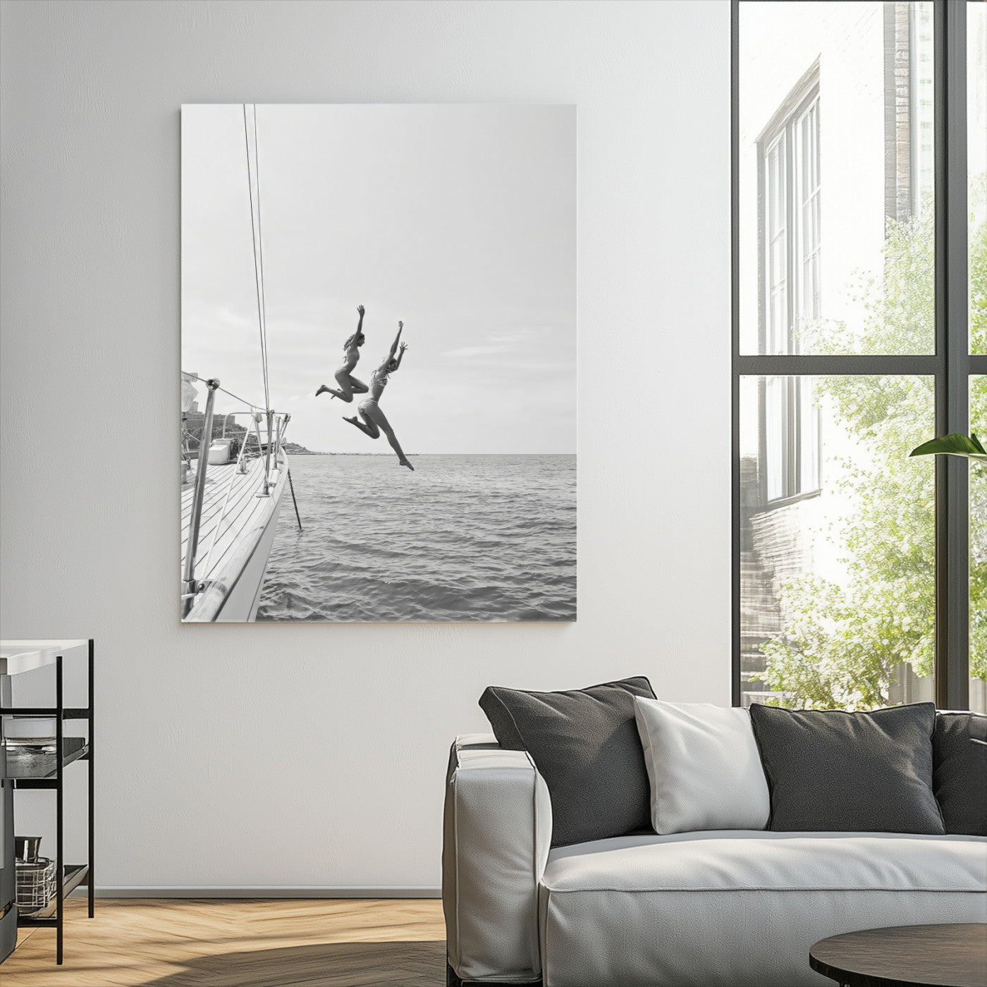 Black and white canvas wall art of two women joyfully jumping off a yacht into the sea, ideal for minimalist coastal or nautical-themed spaces.