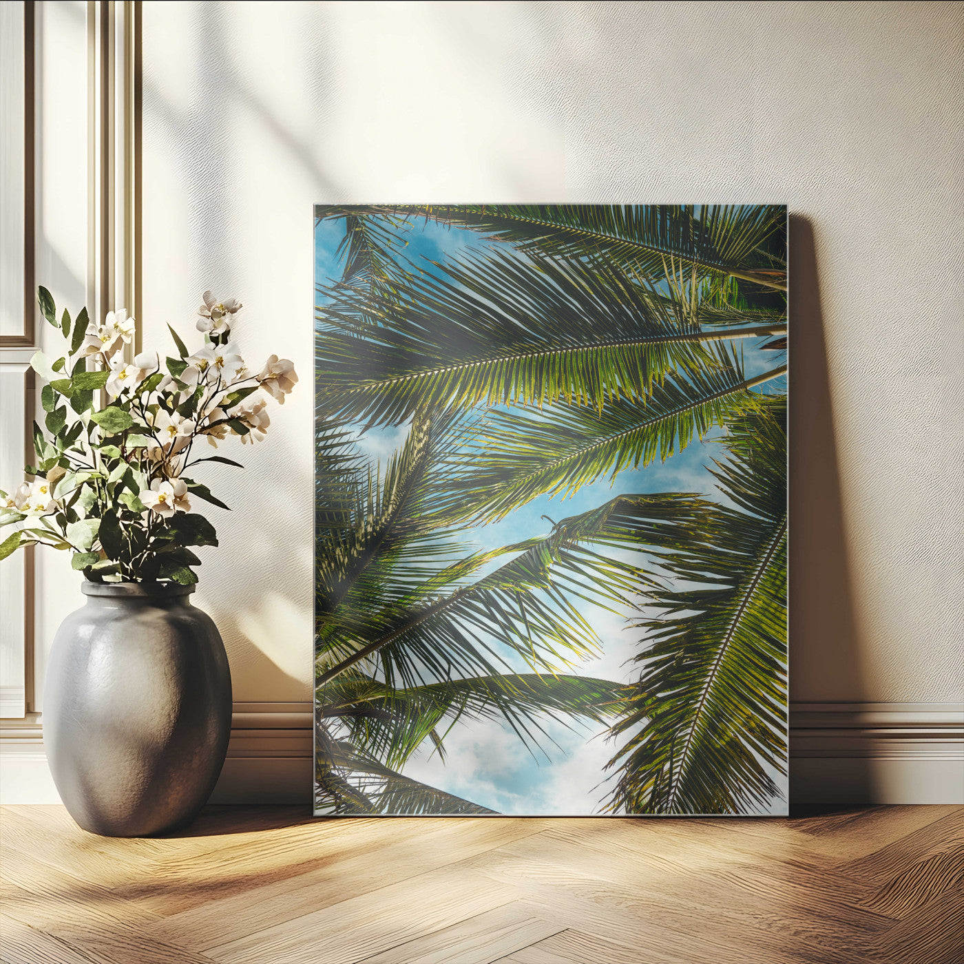 Looking up at lush green palm leaves against a bright blue sky, creating a tropical and relaxing coastal aesthetic.