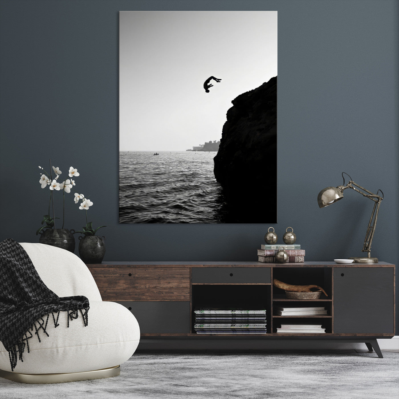 Silhouette of a person mid-air during a cliff jump over the ocean, captured in black and white for minimalist adventure decor.