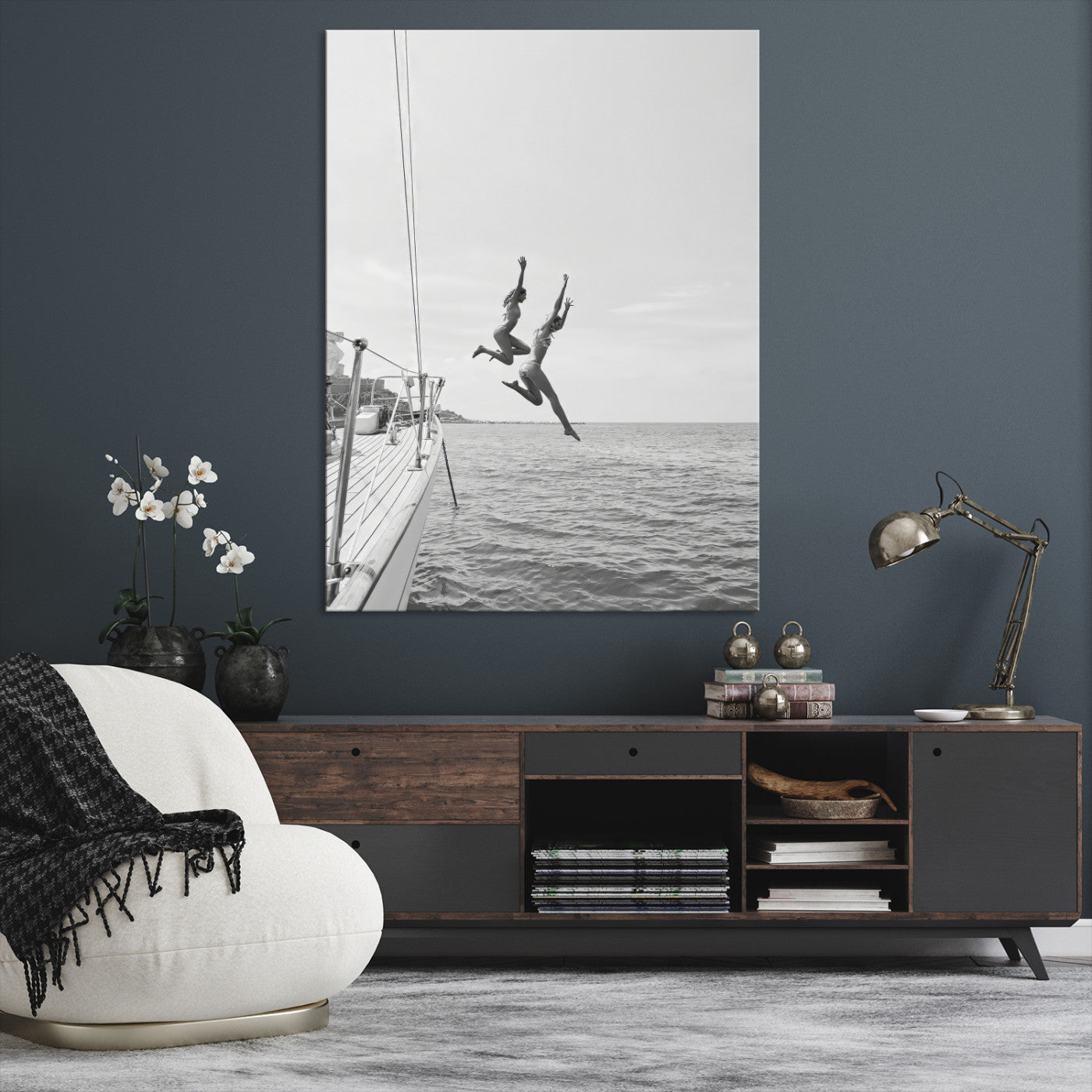 Black and white canvas wall art of two women joyfully jumping off a yacht into the sea, ideal for minimalist coastal or nautical-themed spaces.