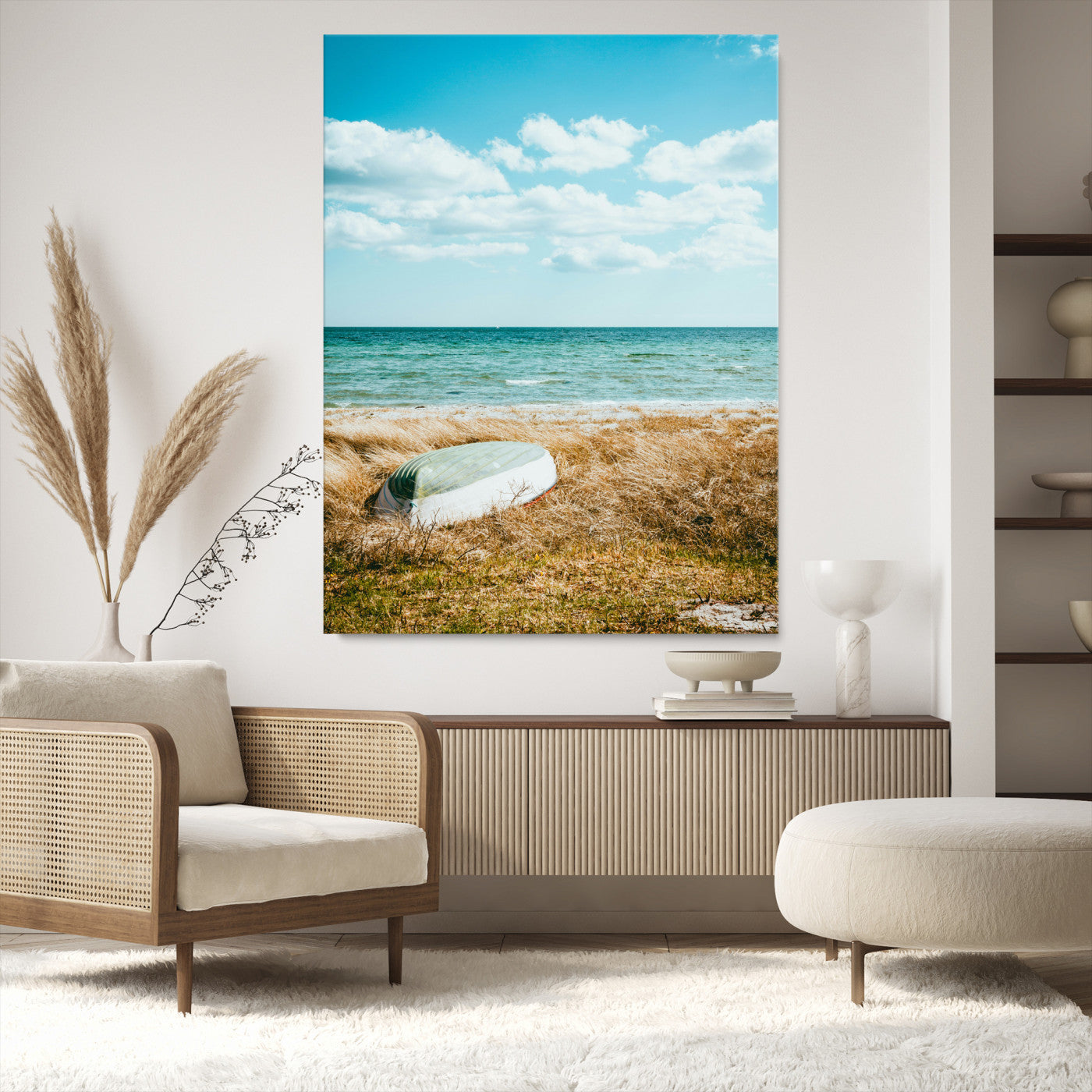 A small boat resting on a grassy shore with ocean waves and a bright blue sky, creating a peaceful coastal atmosphere.
