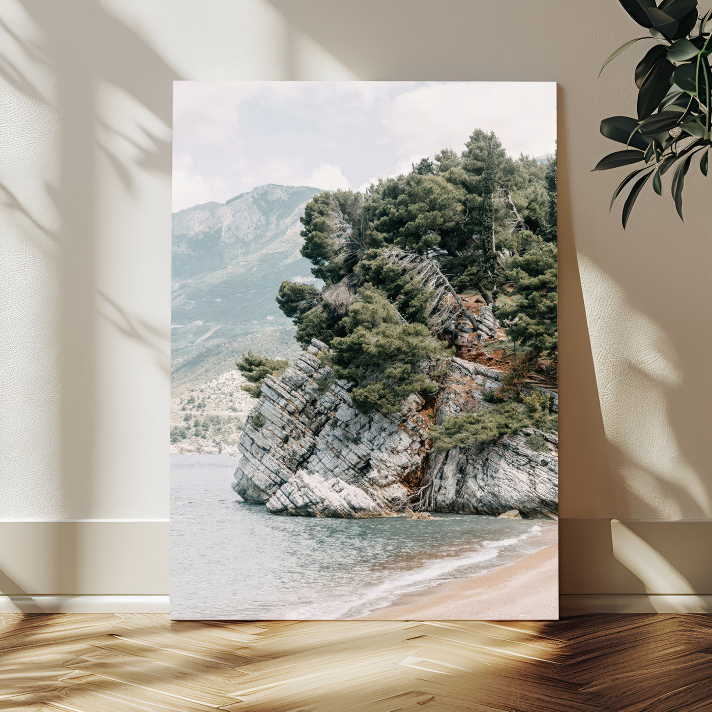 Framed photo of a rocky coastal cliff with dense greenery and calm shoreline, ideal for rustic coastal or earthy-toned home decor.