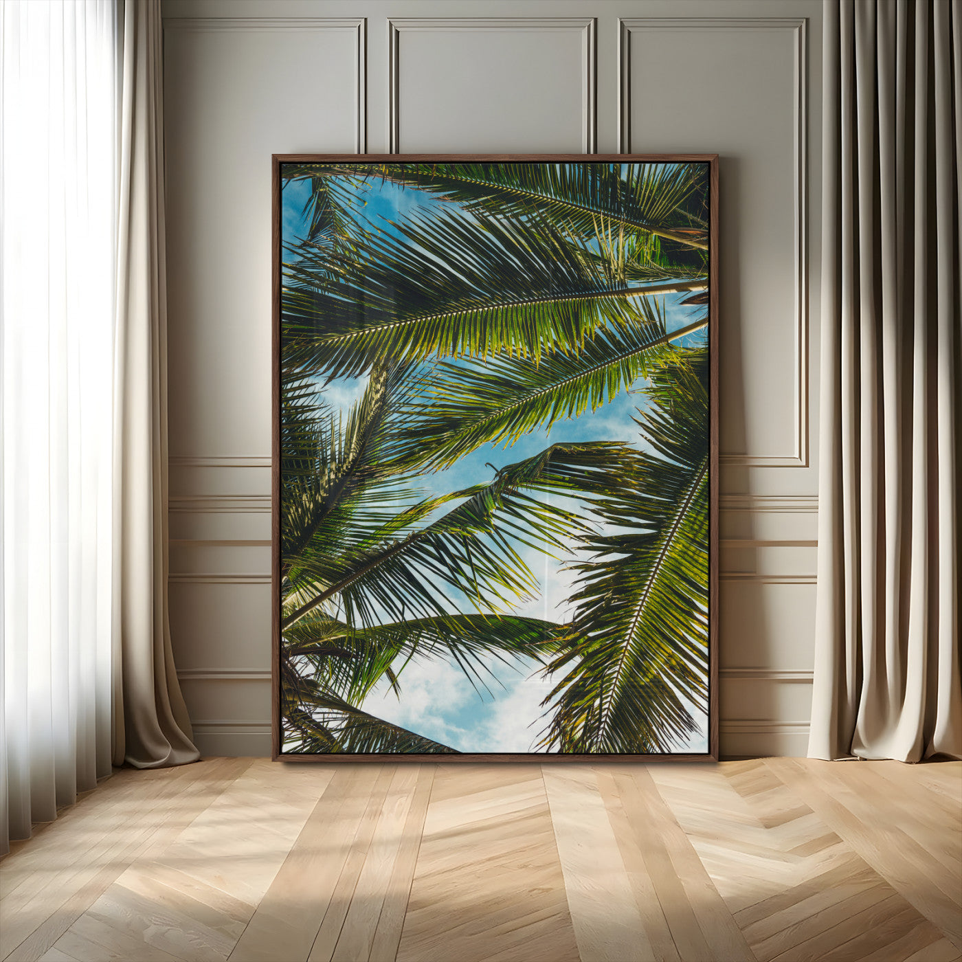 Looking up at lush green palm leaves against a bright blue sky, creating a tropical and relaxing coastal aesthetic.