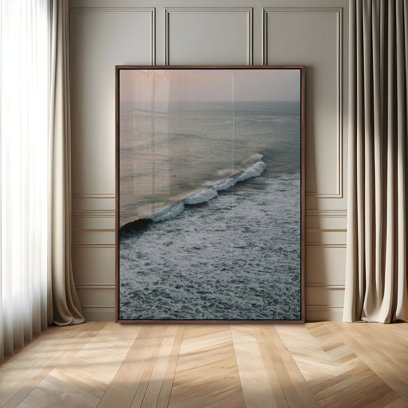 Aerial view of ocean waves rolling towards the shore under a soft sunset sky, creating a peaceful and minimalist coastal scene.