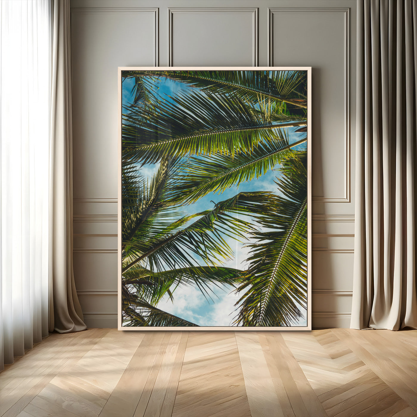 Looking up at lush green palm leaves against a bright blue sky, creating a tropical and relaxing coastal aesthetic.