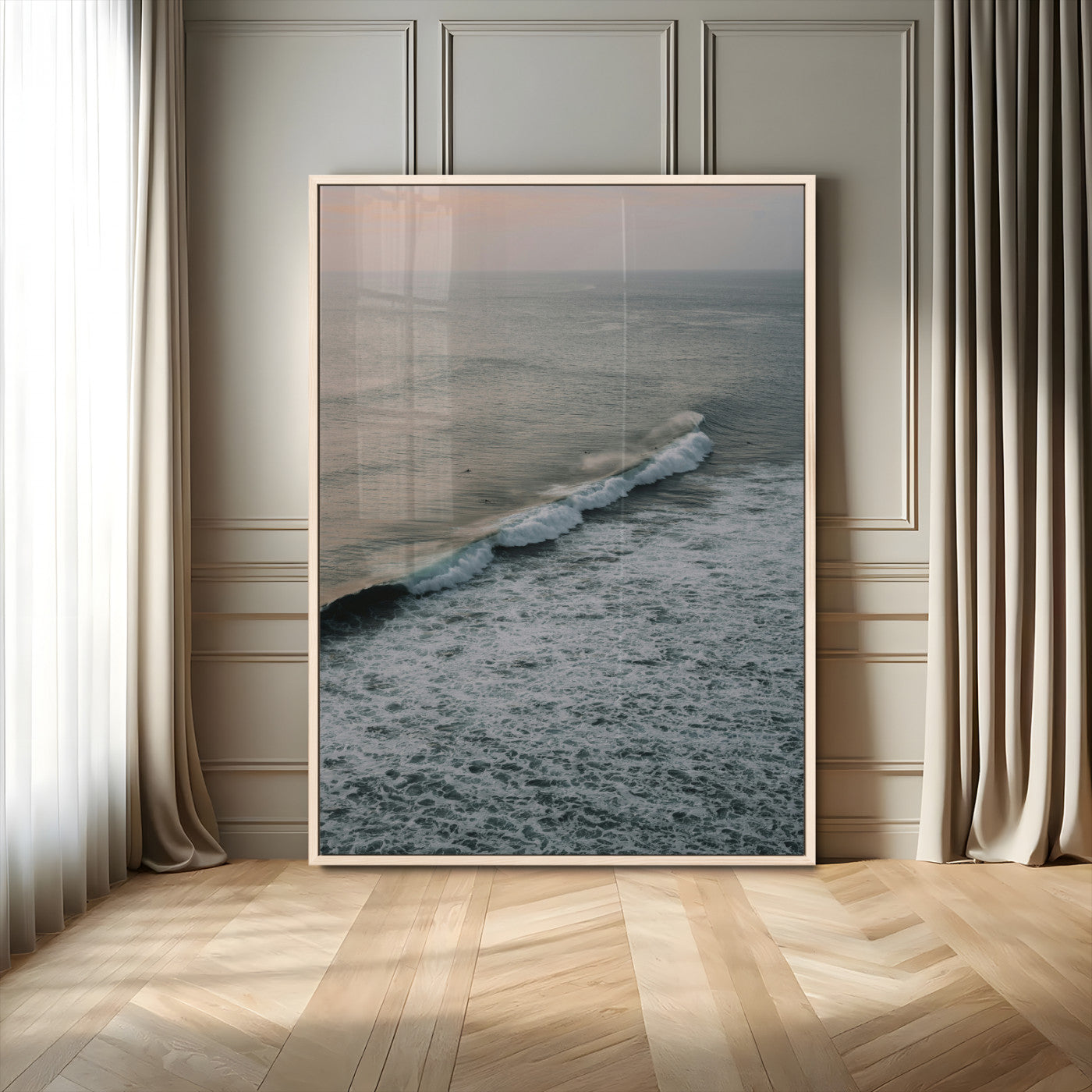 Aerial view of ocean waves rolling towards the shore under a soft sunset sky, creating a peaceful and minimalist coastal scene.