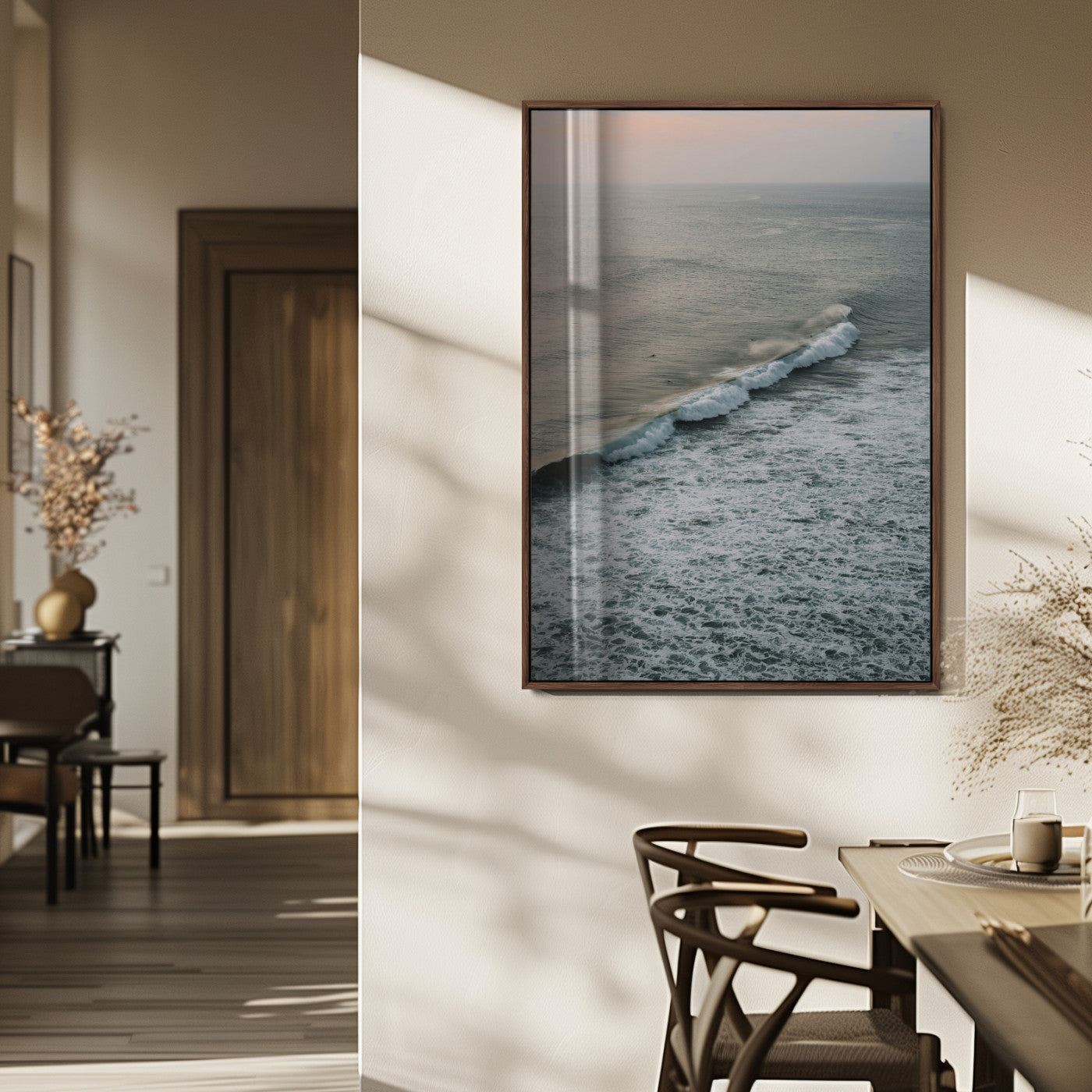Aerial view of ocean waves rolling towards the shore under a soft sunset sky, creating a peaceful and minimalist coastal scene.