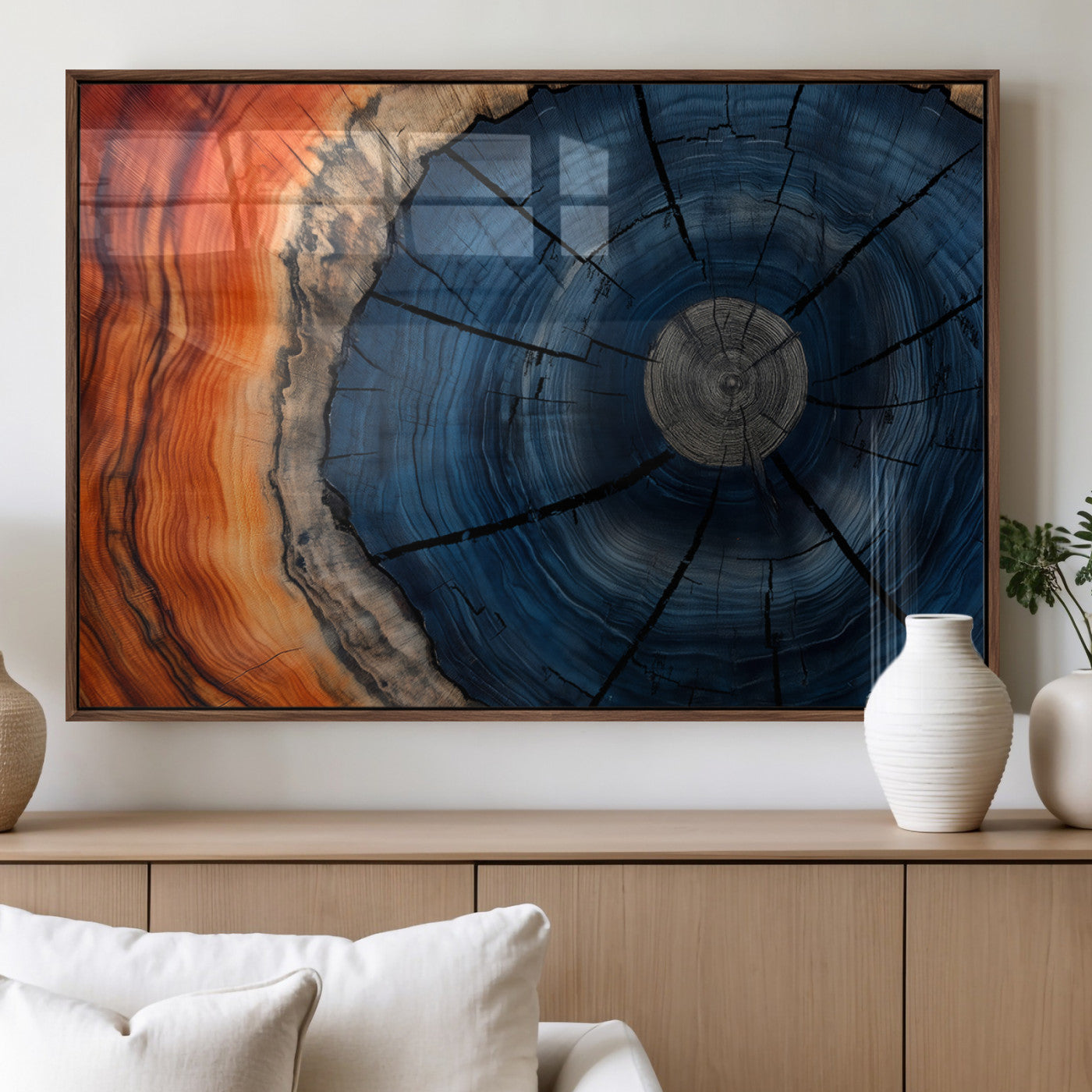 A captivating close-up of a tree trunk, showcasing its concentric rings in rich shades of blue, orange, and brown, highlighting the organic patterns of natural wood.