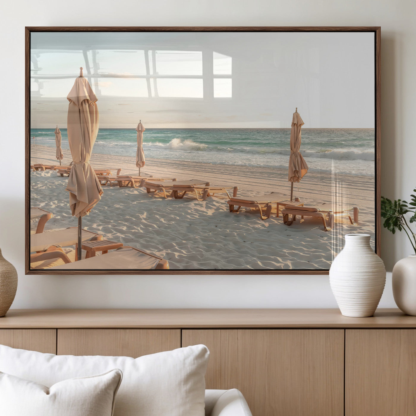 Minimalist photo of empty beach loungers and umbrellas on soft sand, ideal for calm seaside or pastel coastal-style home decor.