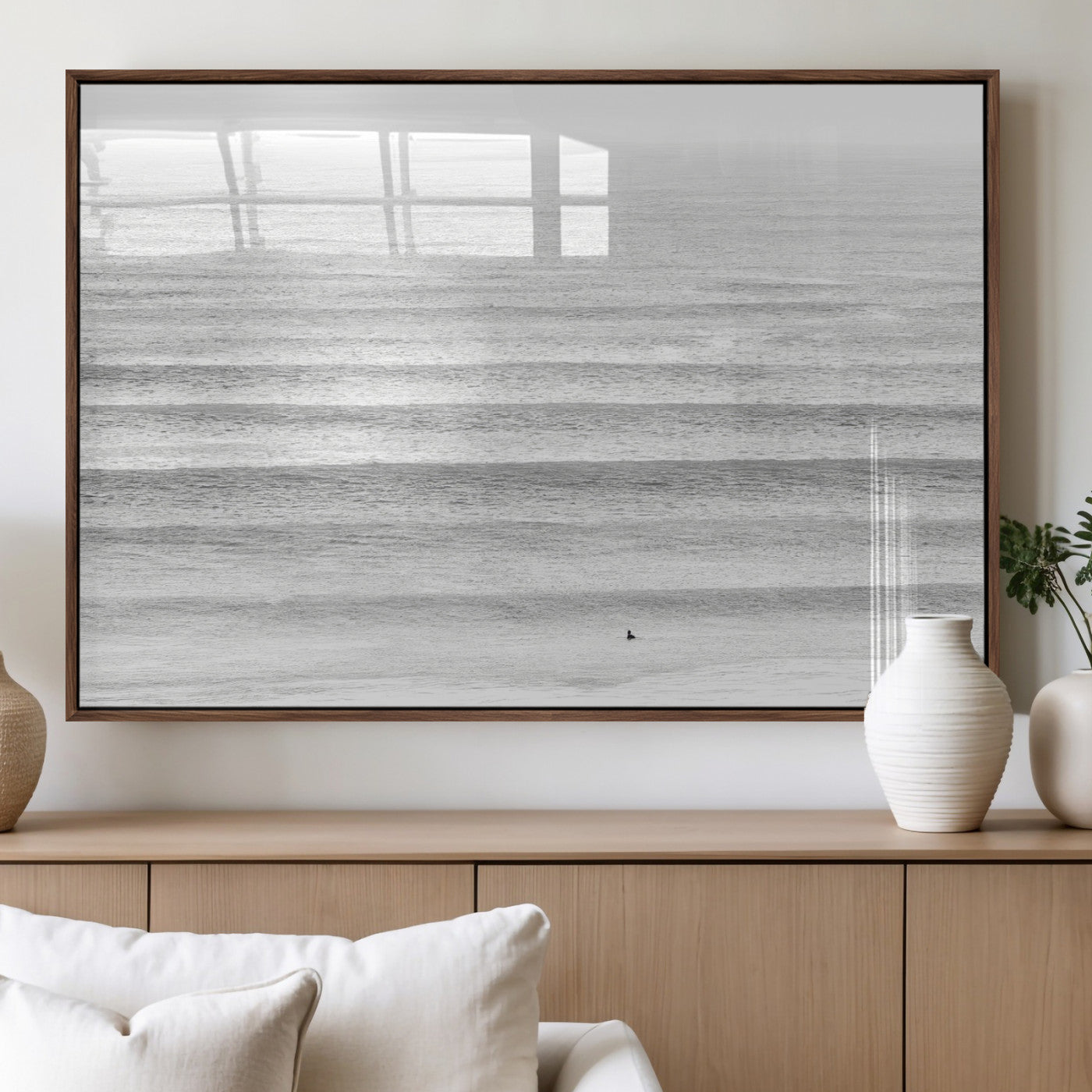 Monochrome photo of a lone surfer in calm layered waves, perfect for minimalist coastal or moody ocean-inspired wall decoration.