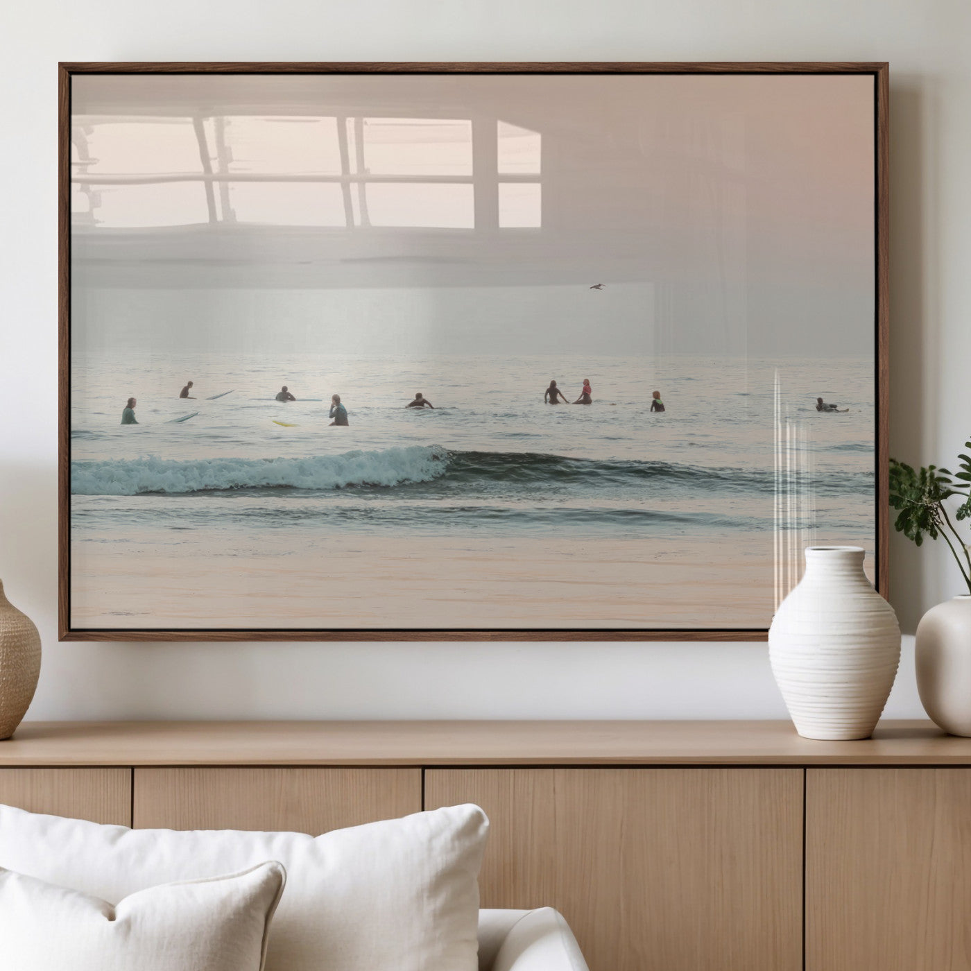 Dreamy photo of surfers waiting on soft pastel waves under a pink sunset sky, ideal for soft coastal minimalist or serene ocean-themed home decor.