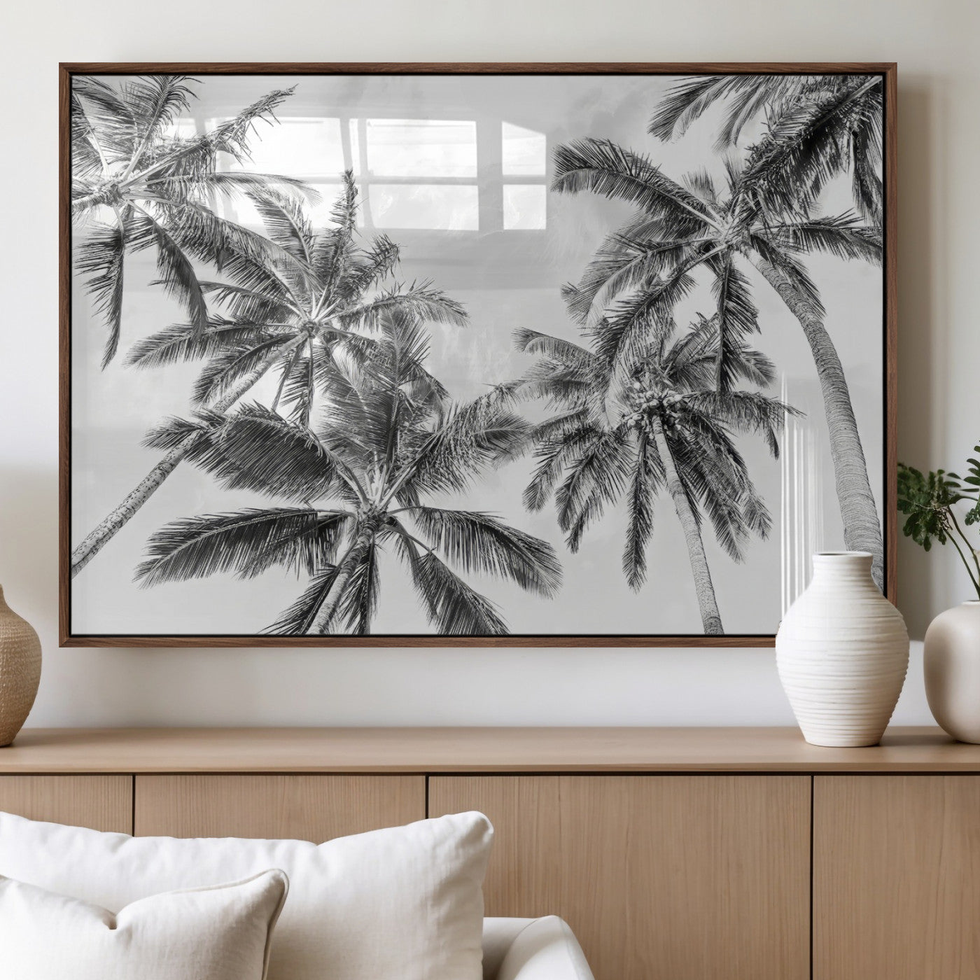 Black and white tropical palm trees viewed from below, swaying gently against a bright sky, creating a serene and elegant coastal atmosphere.