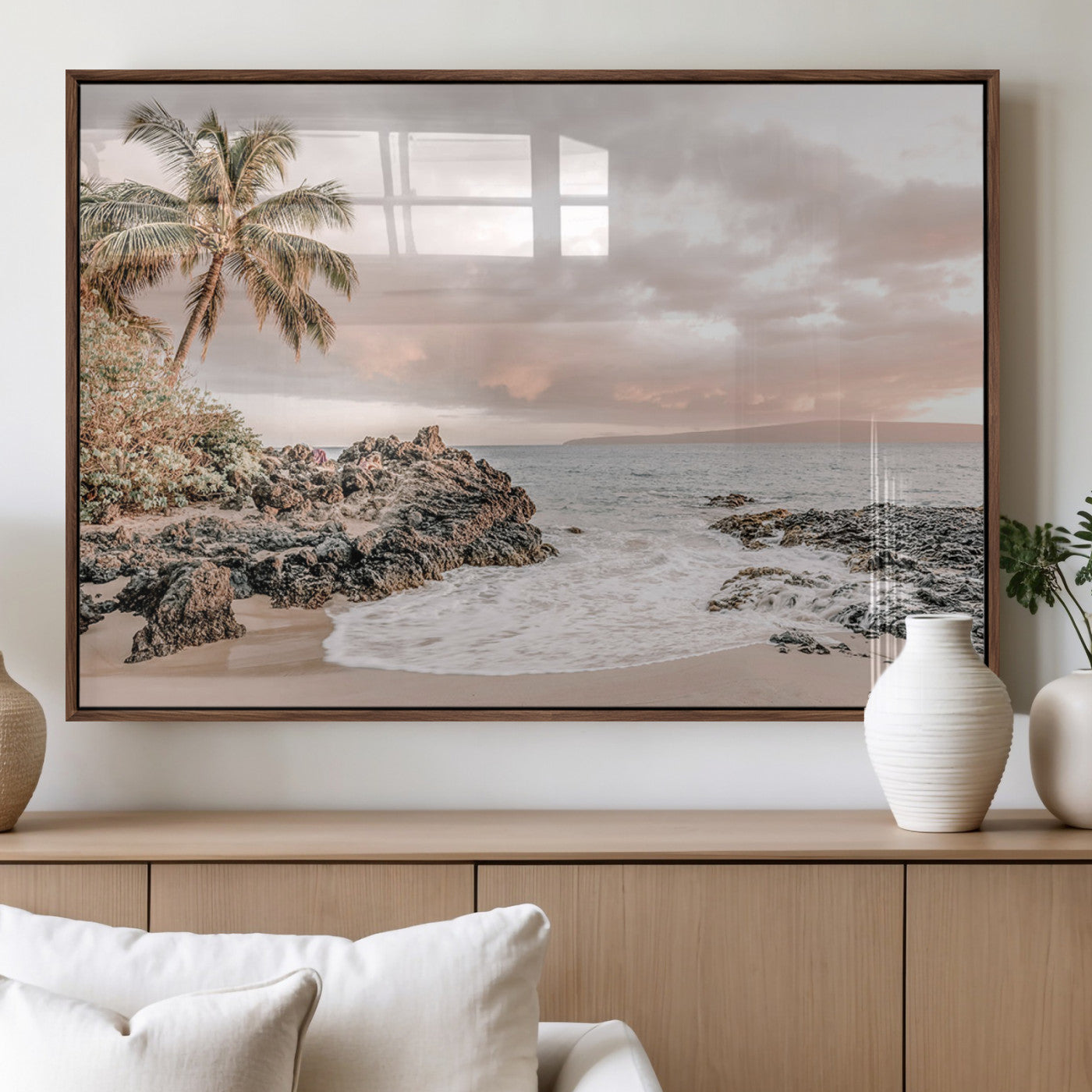 A peaceful beach scene with a palm tree and rocks, soft waves washing onto the shore under a soft pastel sky at sunset.