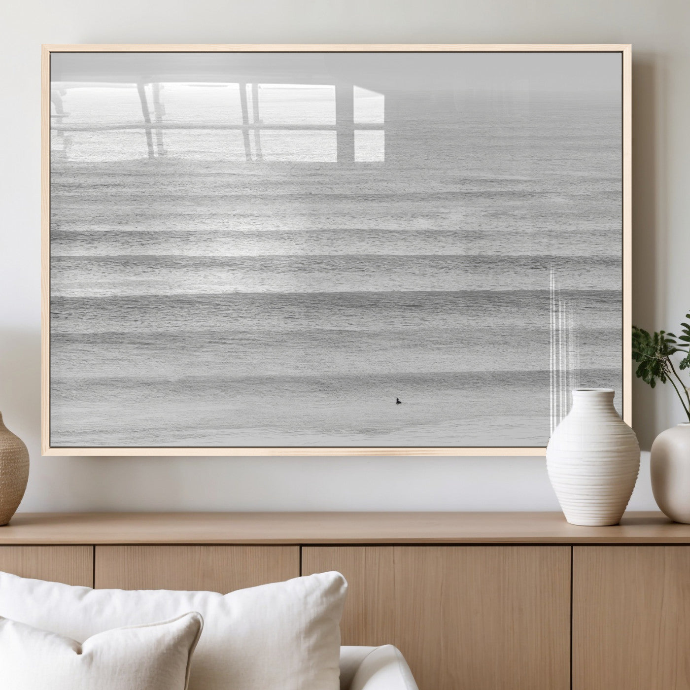 Monochrome photo of a lone surfer in calm layered waves, perfect for minimalist coastal or moody ocean-inspired wall decoration.