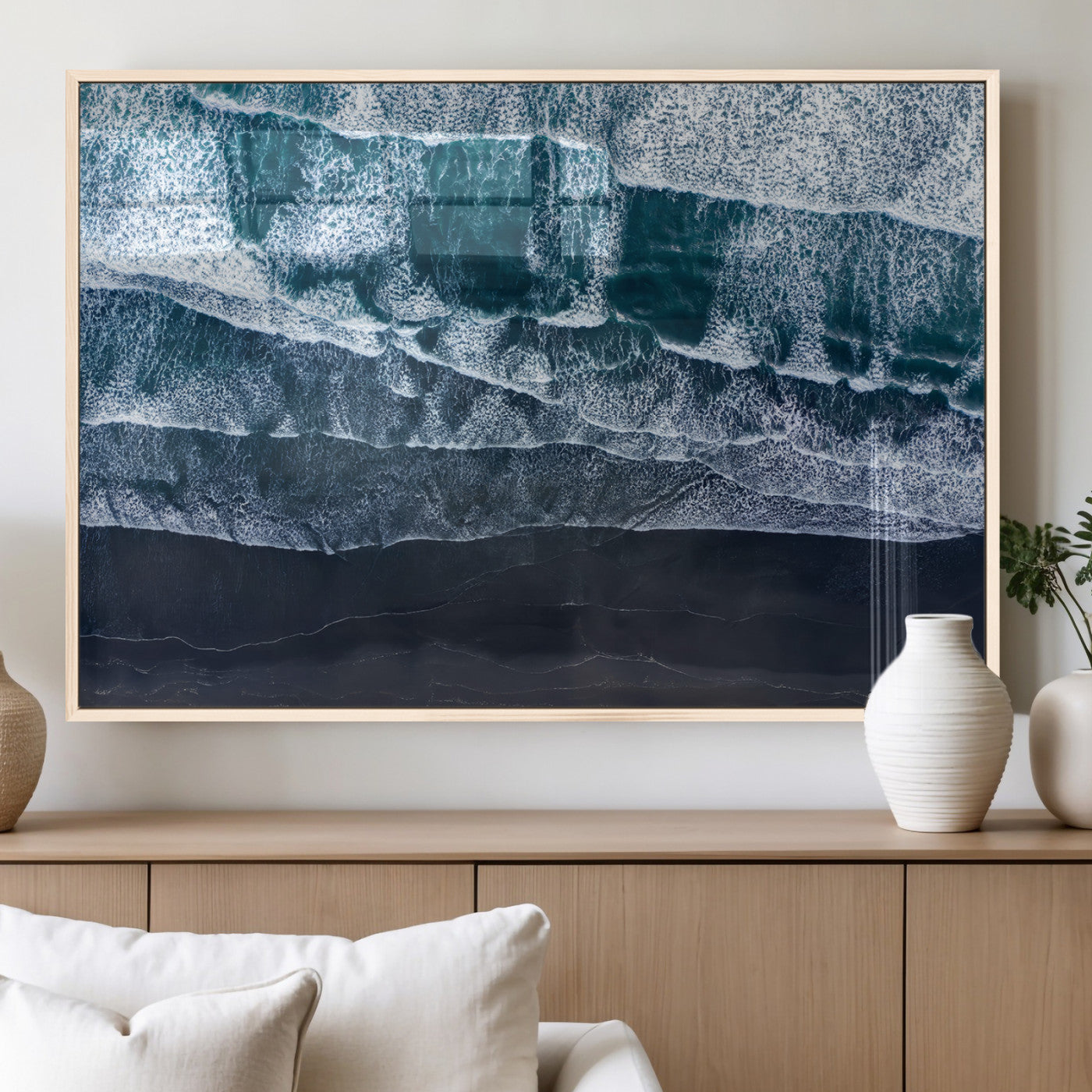 Canvas of aerial ocean waves crashing onto a black sand beach in moody tones, ideal for modern coastal or minimalist home decor.